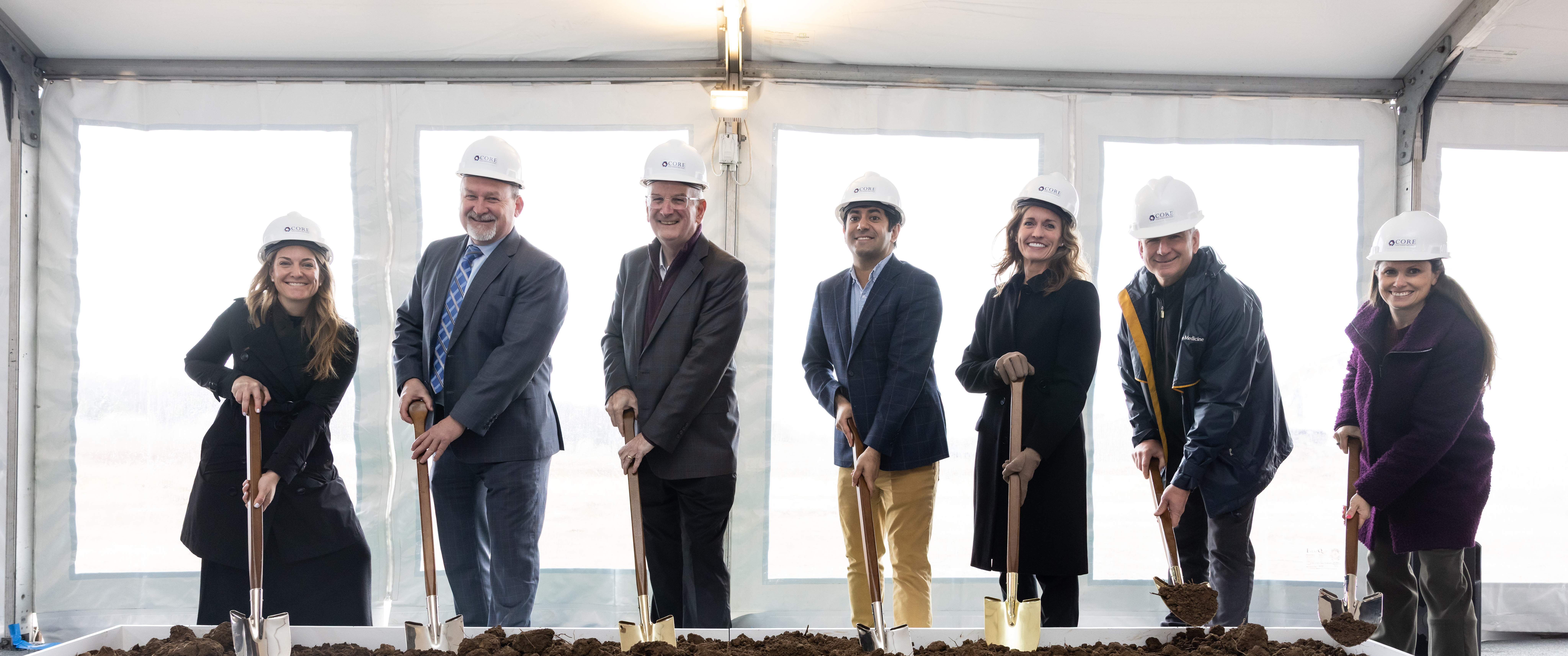 A group of leaders wears helmets and holds ceremonial shovels to "break ground" for Penn Medicine Montgomeryville