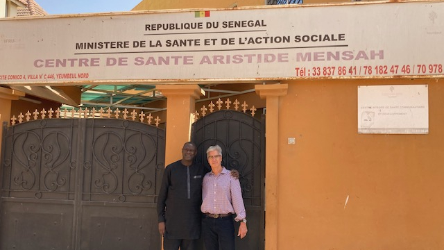 Albert Ruenes and Serigne Gueye standing in front of a health center in Senegal.