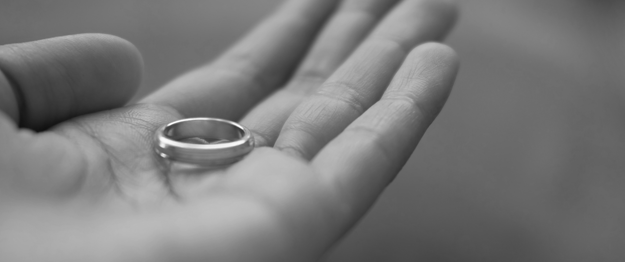 Female hand hold wedding ring in black and white