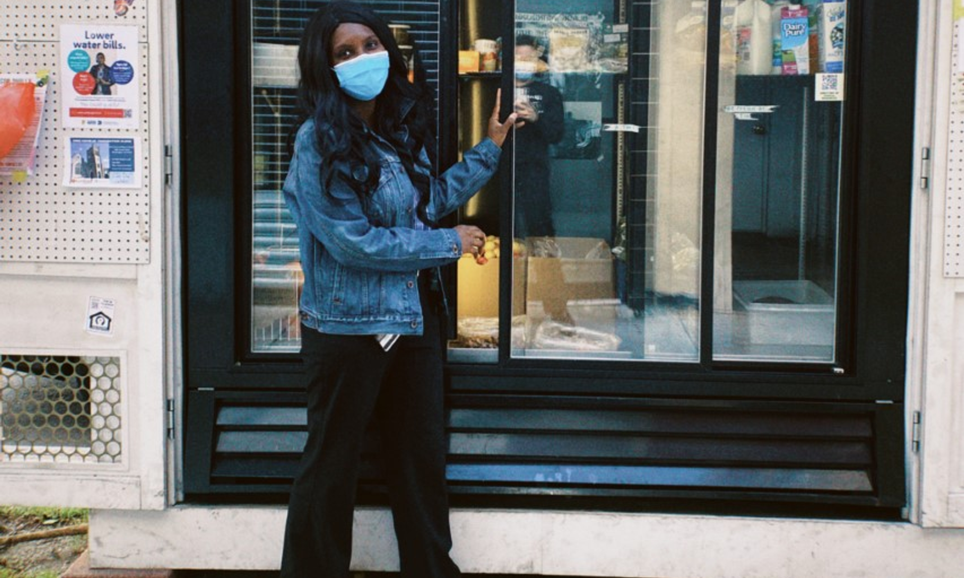 Desauna Dubose stands in front of a refrigerated case in an outdoor shed structure