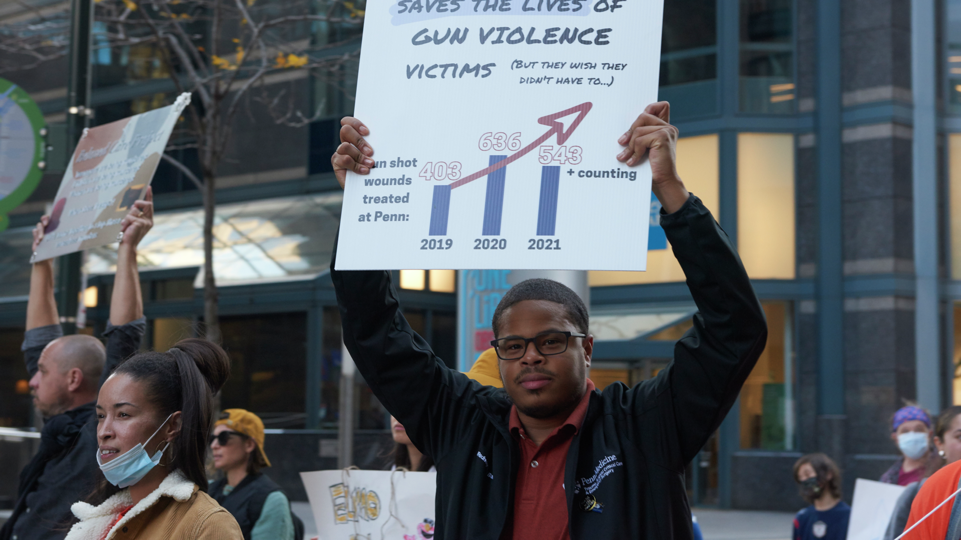 Rodney Babb holds up a sign showing statistics of gun violence victims while marching in a protest