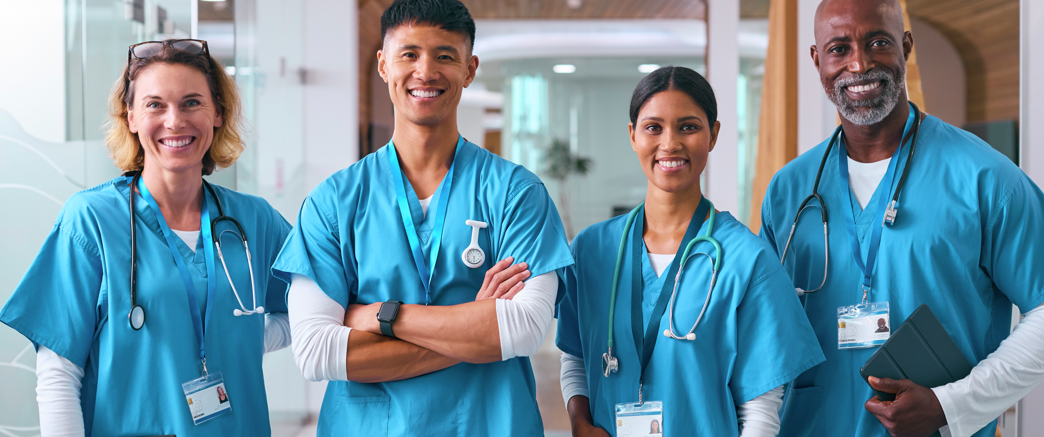 A group of nurses smile in hospital hallway