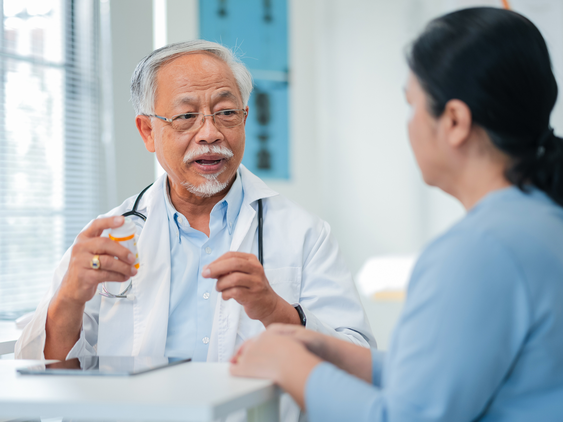 doctor holding medicine bottle and talking to patient about Integrative medicine