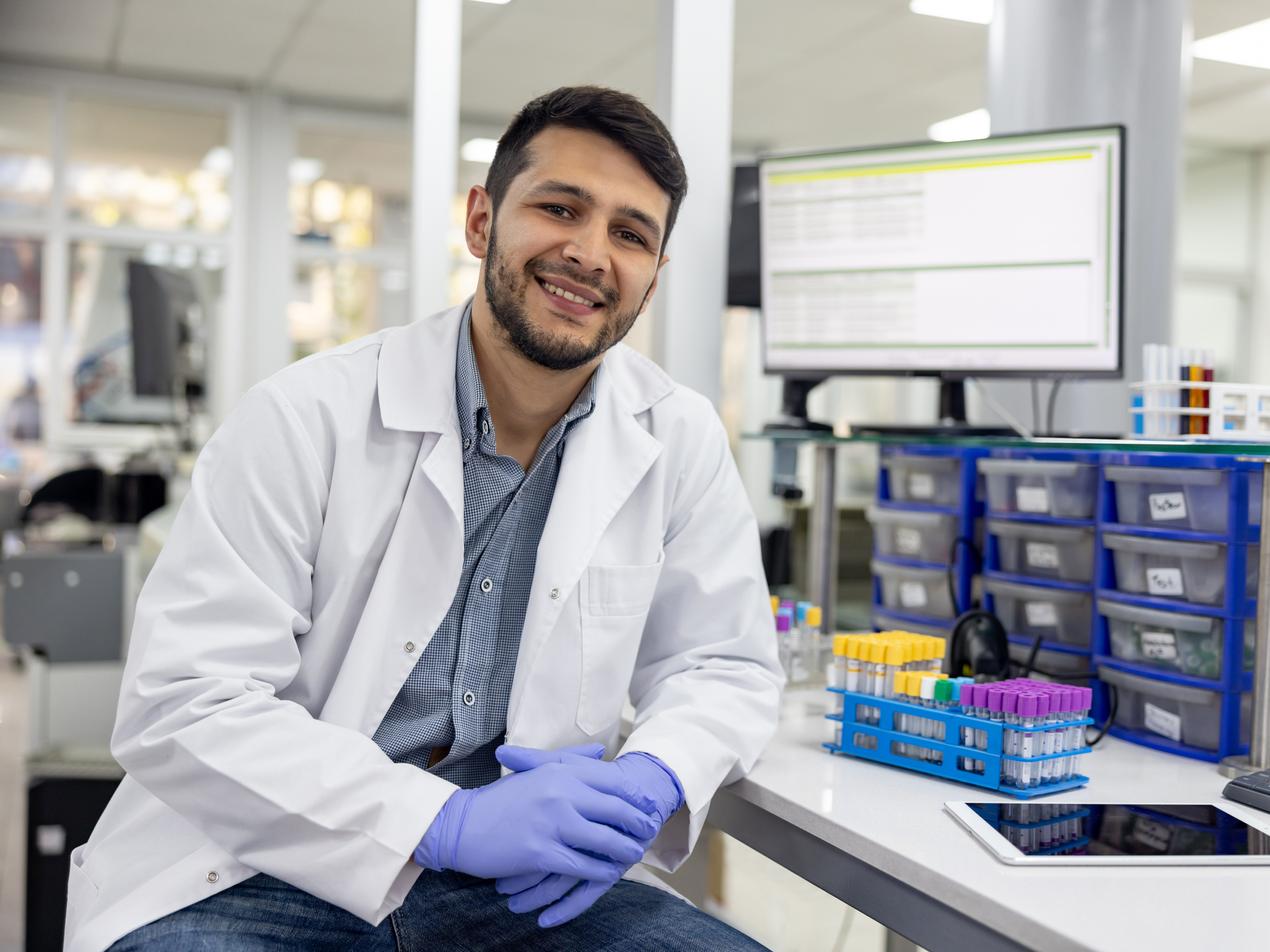  Scientist analyzing blood samples at the laboratory and looking at the camera smiling