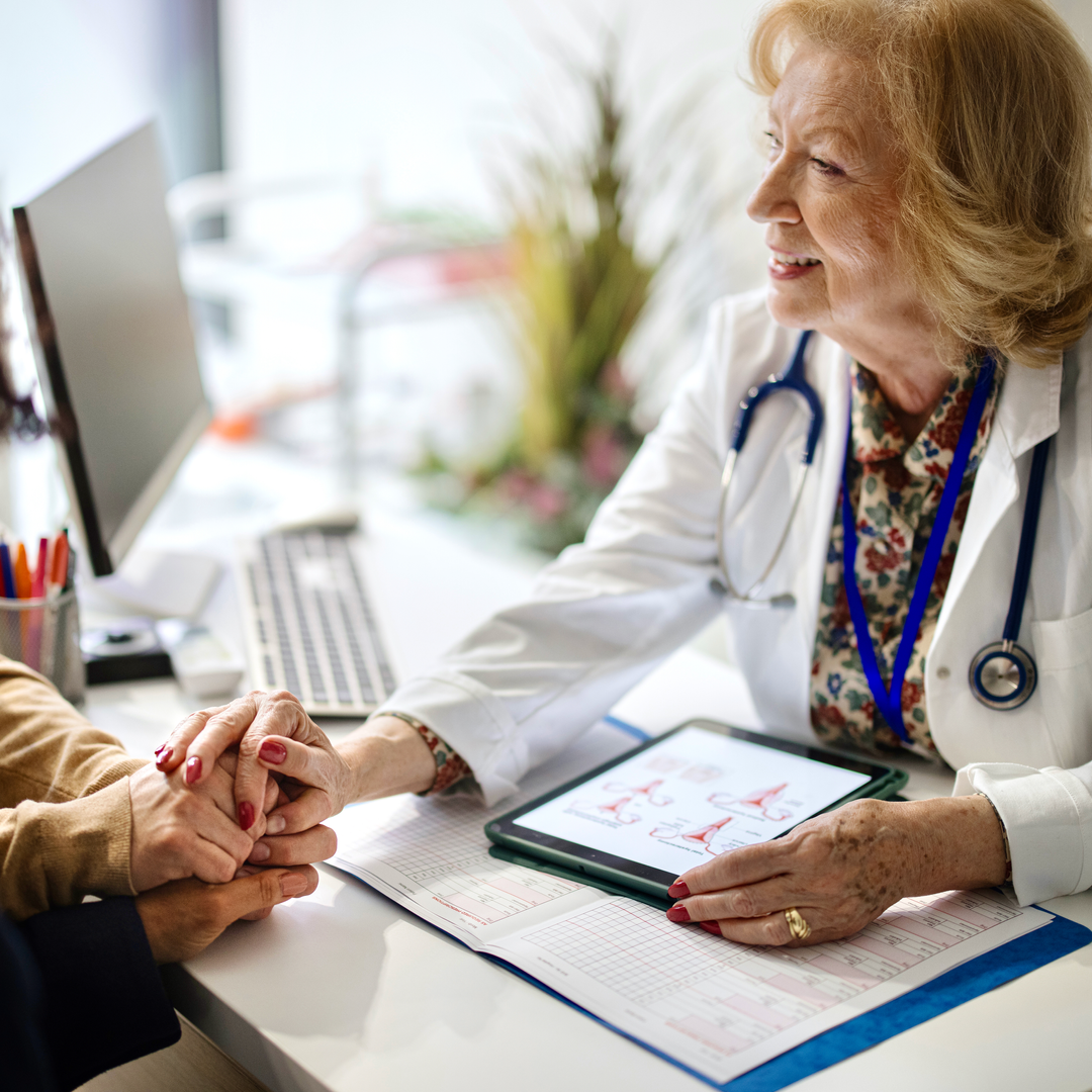 Doctor holding hands with her patients during a consultation