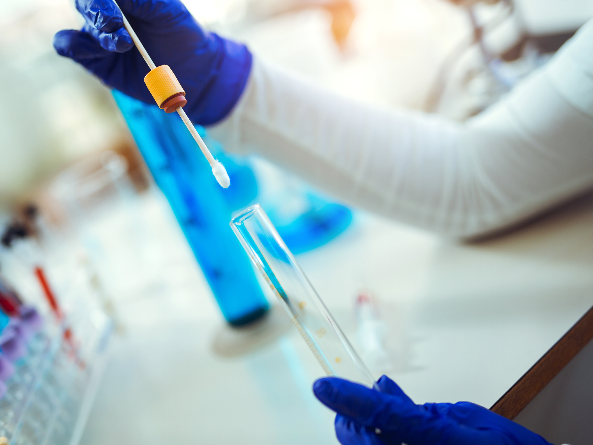 Female forensic technician collecting biological specimen in DNA