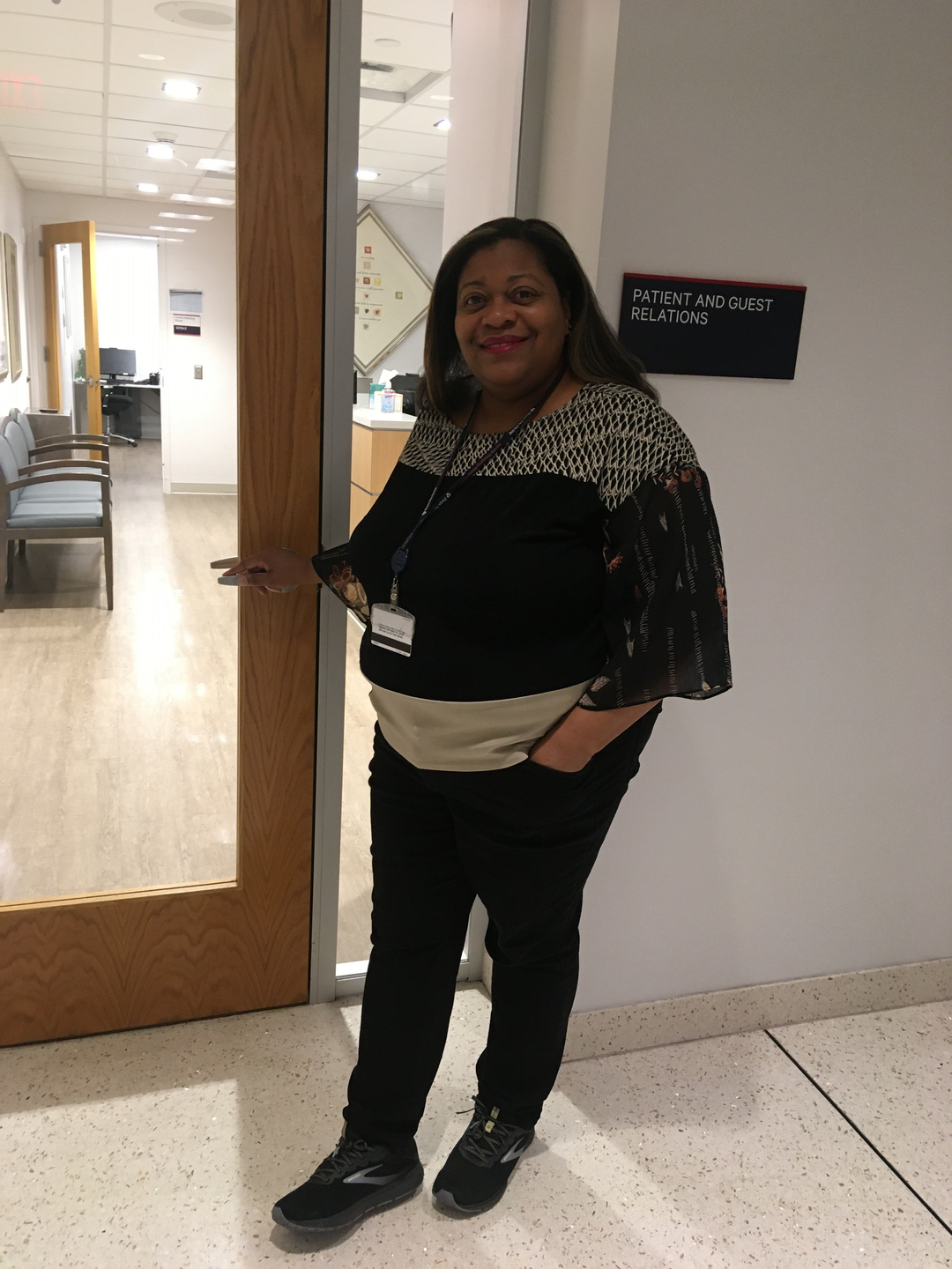 Tan’Nette Grandberry stands outside a door labeled Patient and Guest Relations