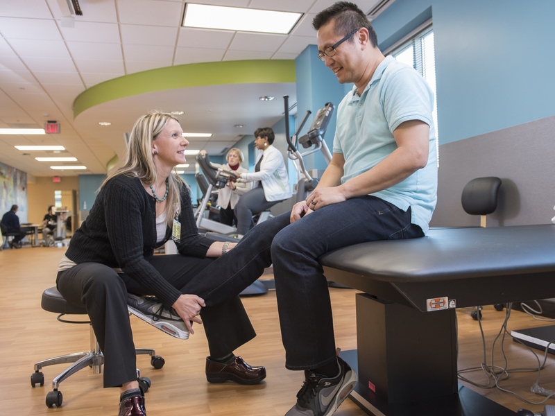 Physical therapist examines patients knee