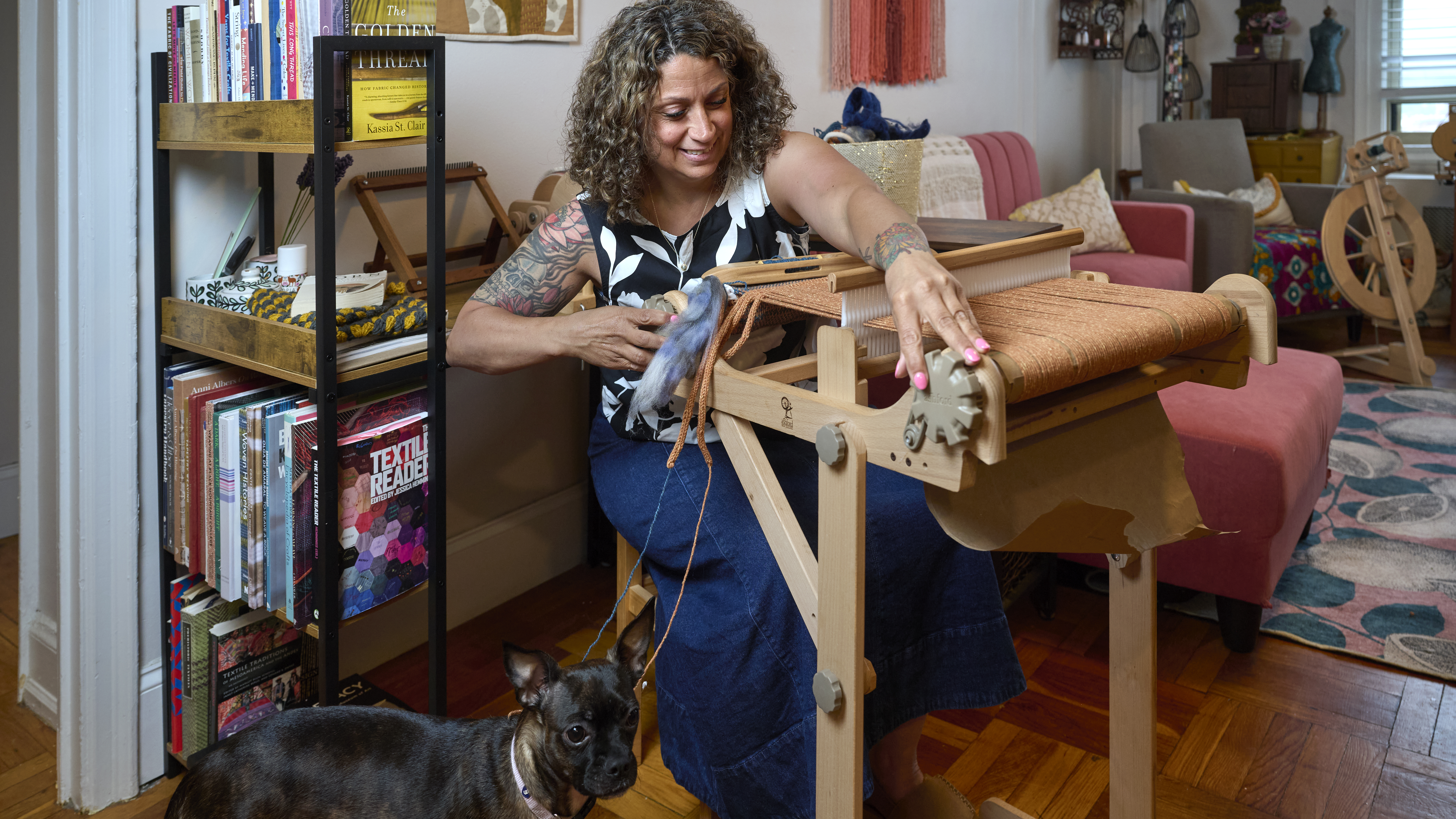 Nurse Linda Ruggiero sitting at the loom, with her dog, Alice, by her side
