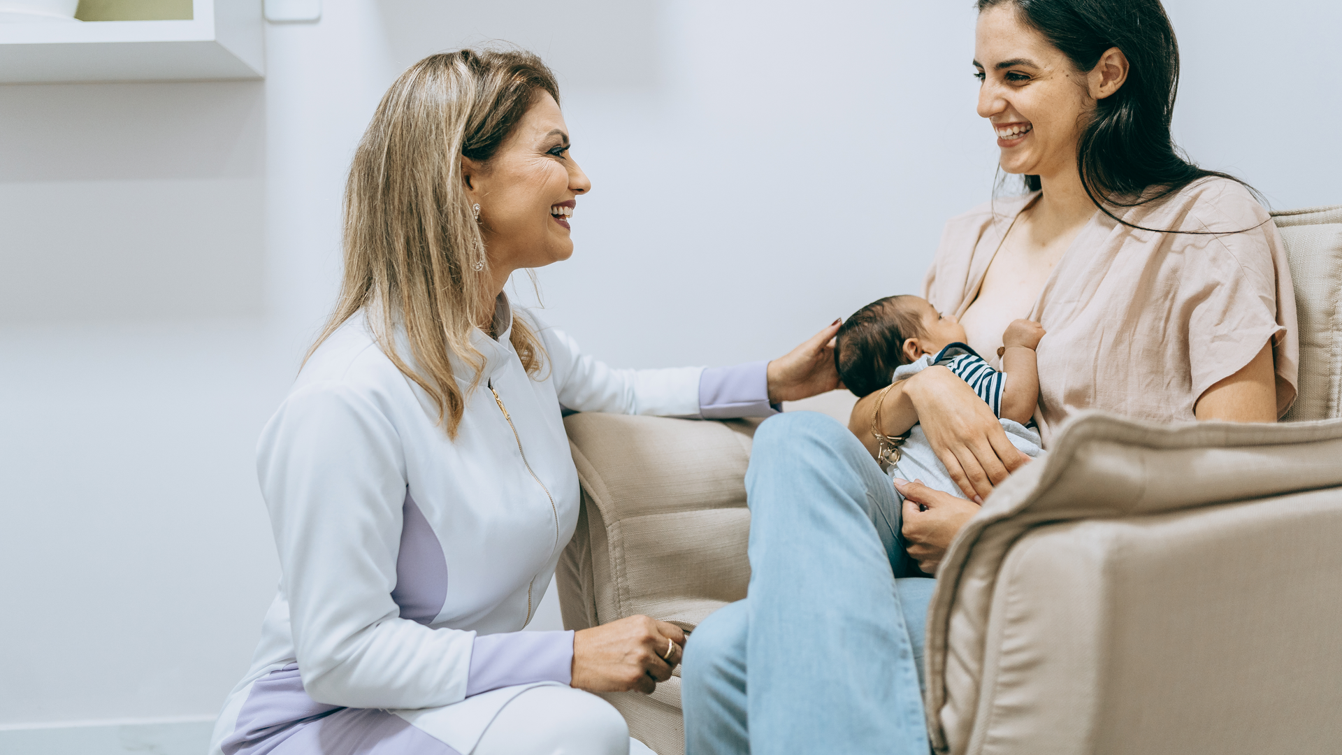 Nurse doula accompanying mother breastfeeding baby