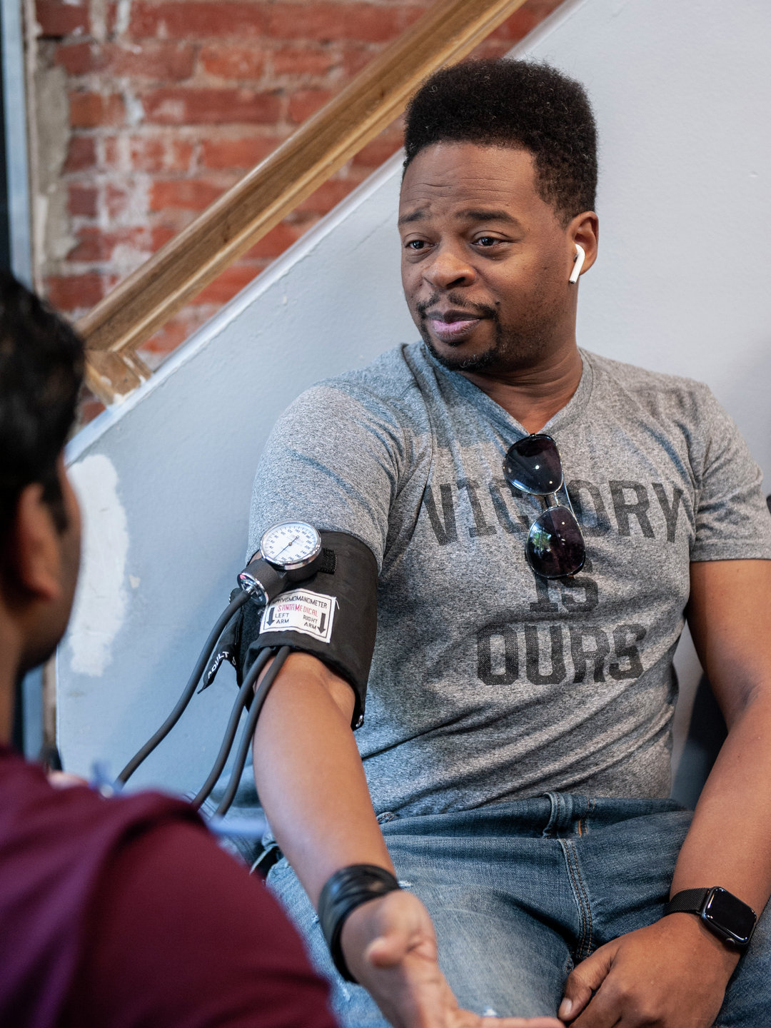 A Black man wearing a blood pressure cuff