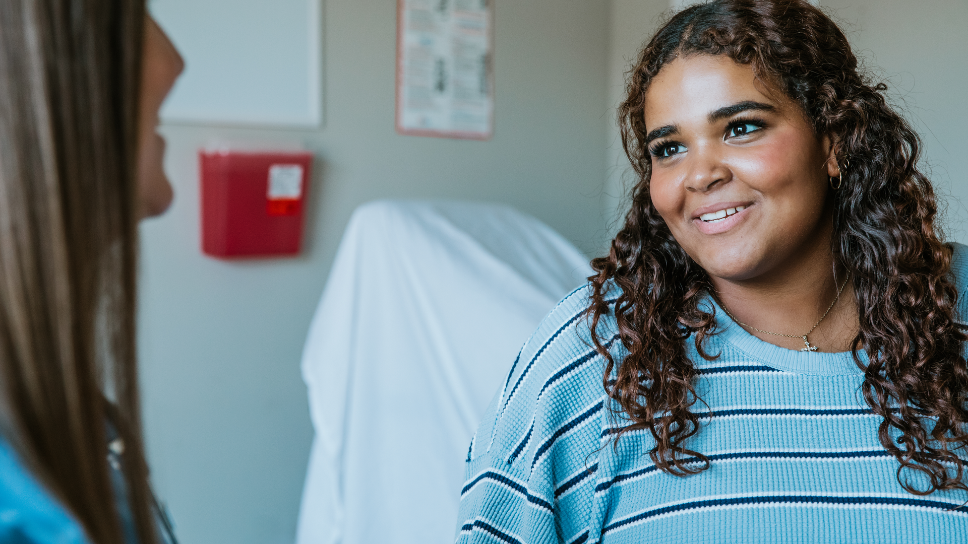 Teenage girl talks with her practitioner about her health concerns