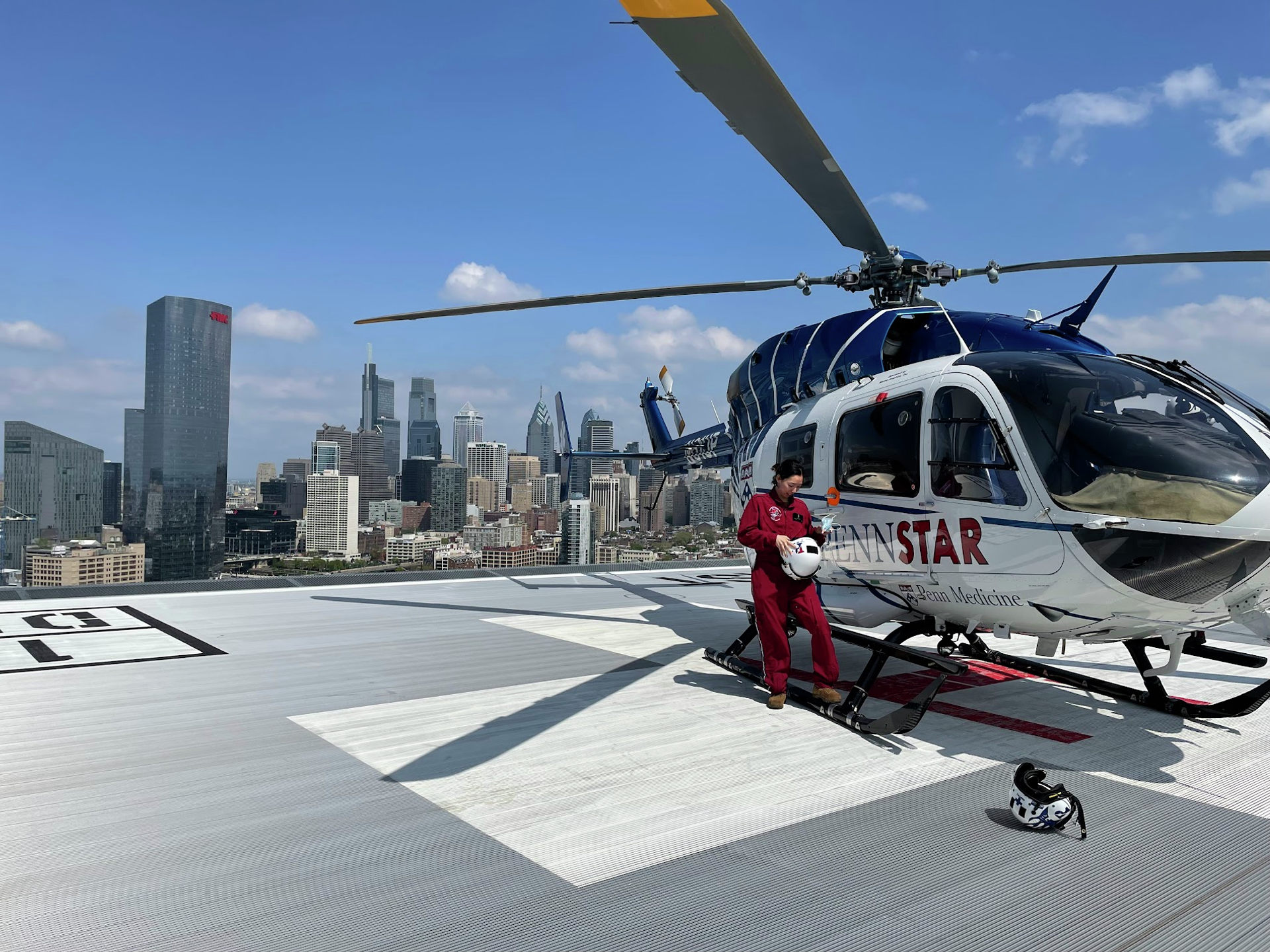 Hyun Kyoung Na standing on a helipad next to the PennSTAR helicopter