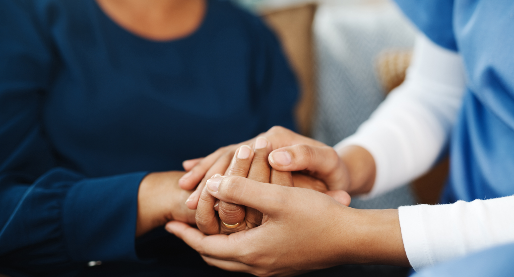 Cropped shot of an unrecognizable nurse holding a patient's hand inside of a doctor's office during the day