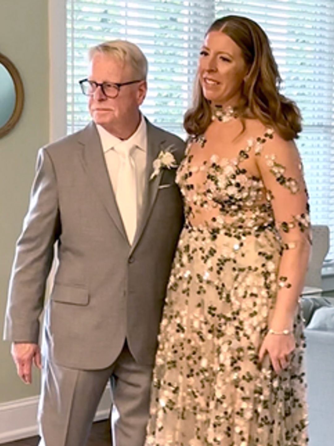 Jim McDevitt standing in a gray suit next to his daughter in a black and white wedding dress.