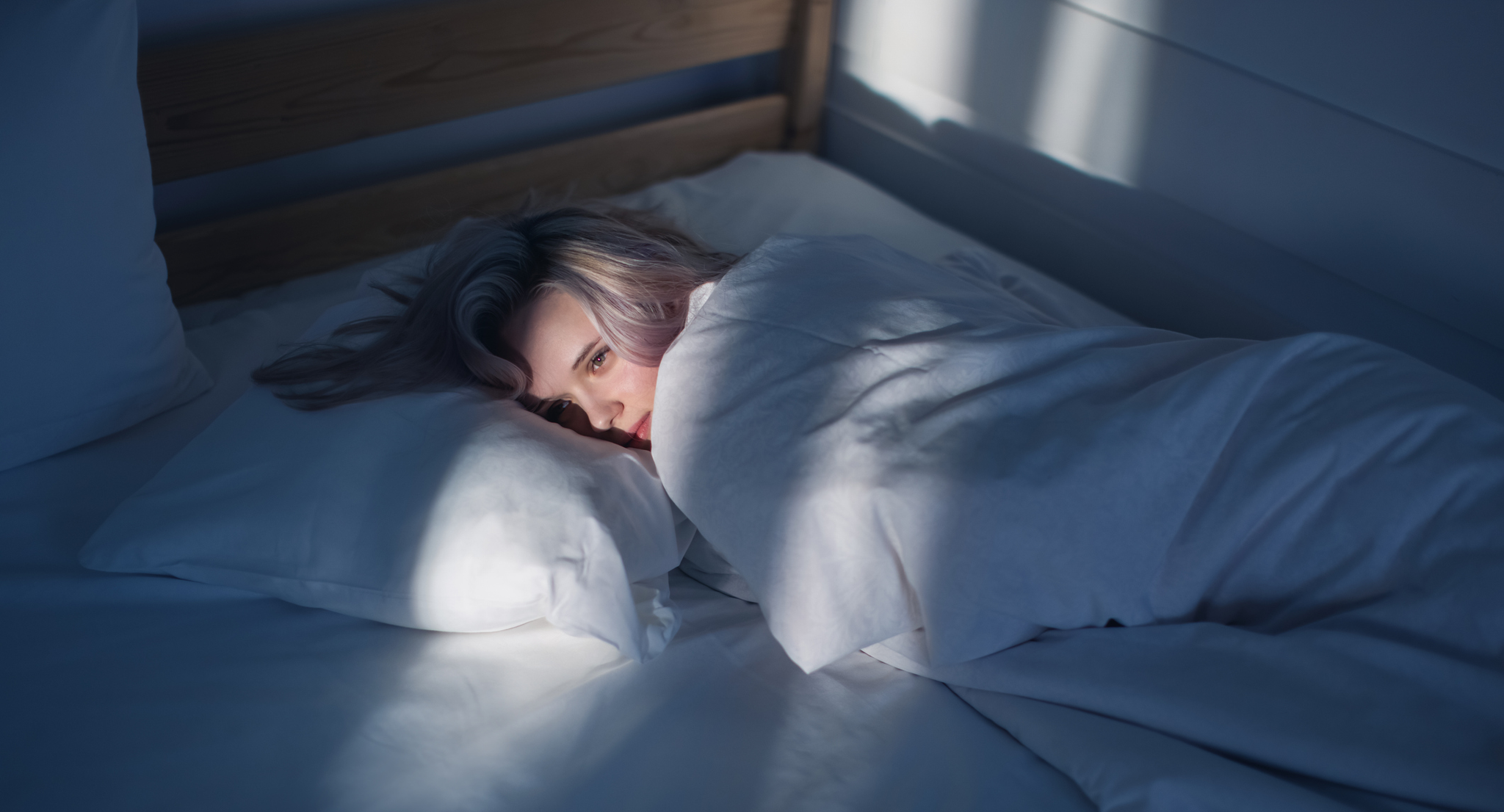A woman lying on a bed, unable to sleep