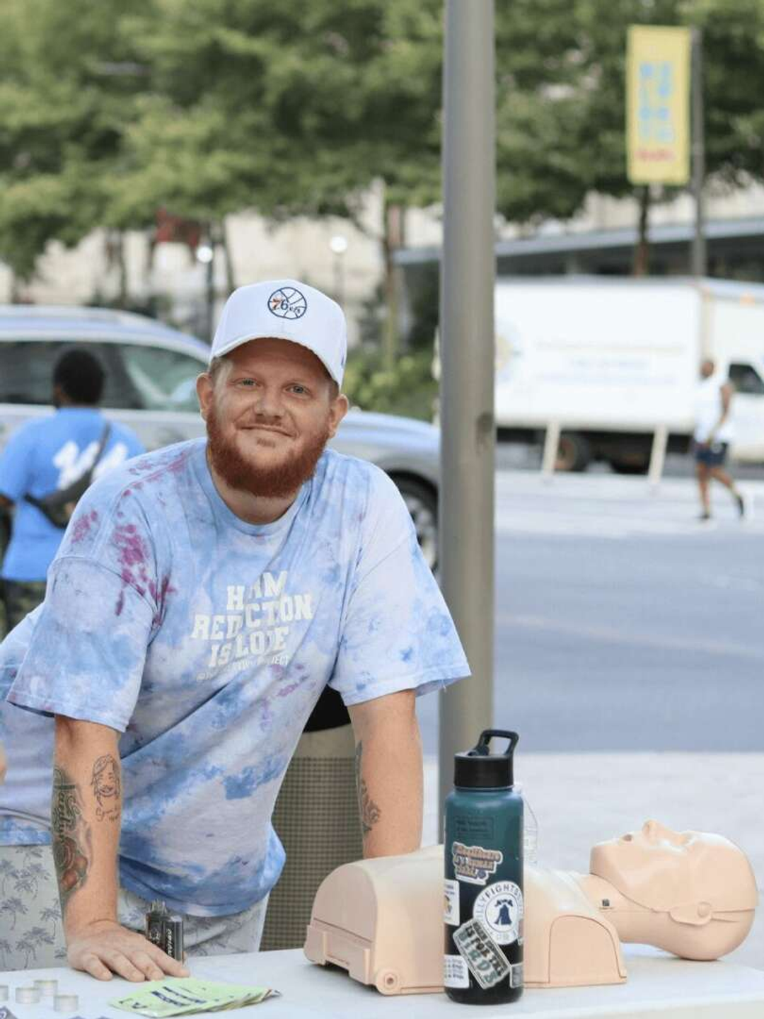 James Sherman standing outside next to a table with a CPR manikin