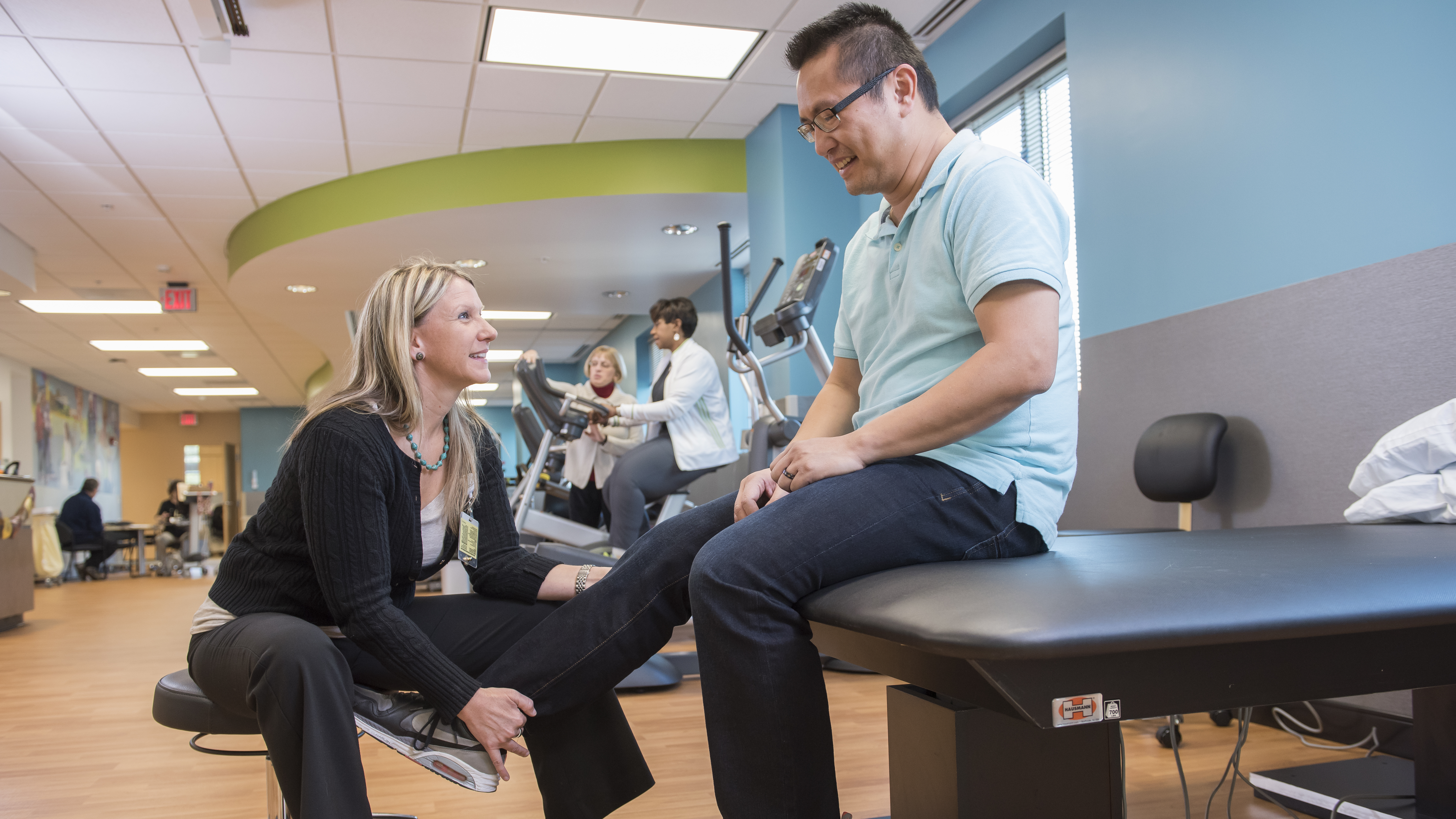 Physical therapist examines patient's knee at Lancaster General Health's Neuroscience Institute Physical Therapy gym