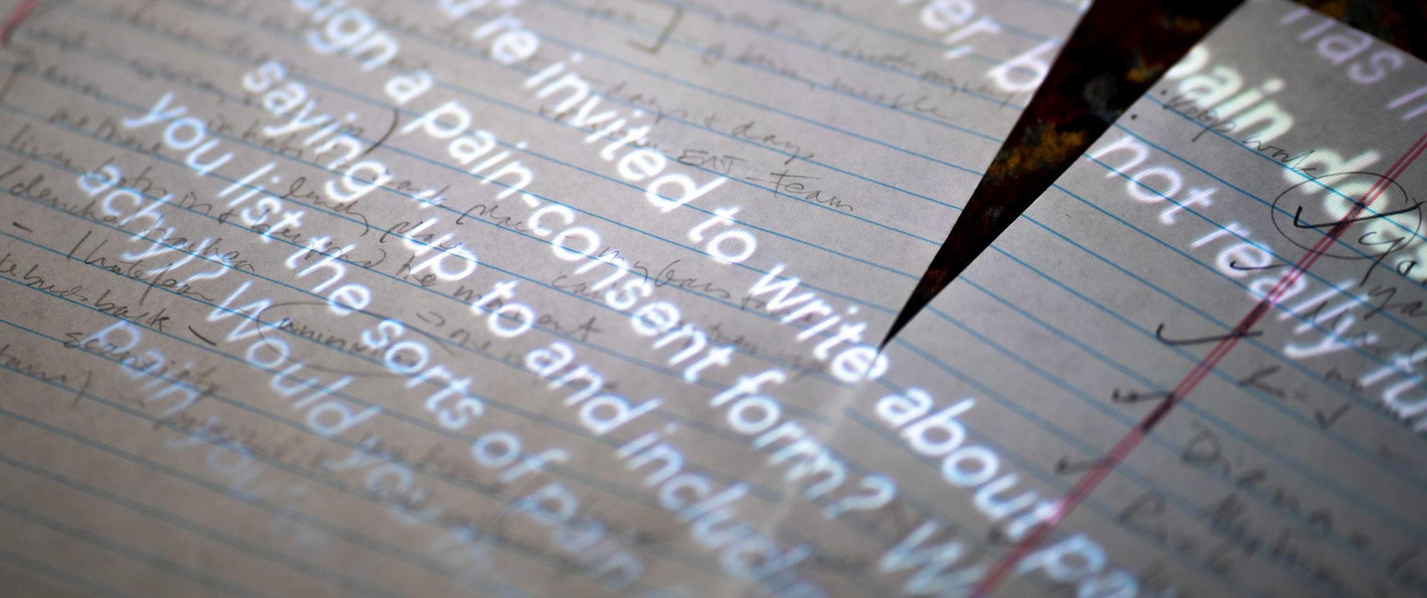 A prompt projected onto notebook paper invites the reader to write about pain