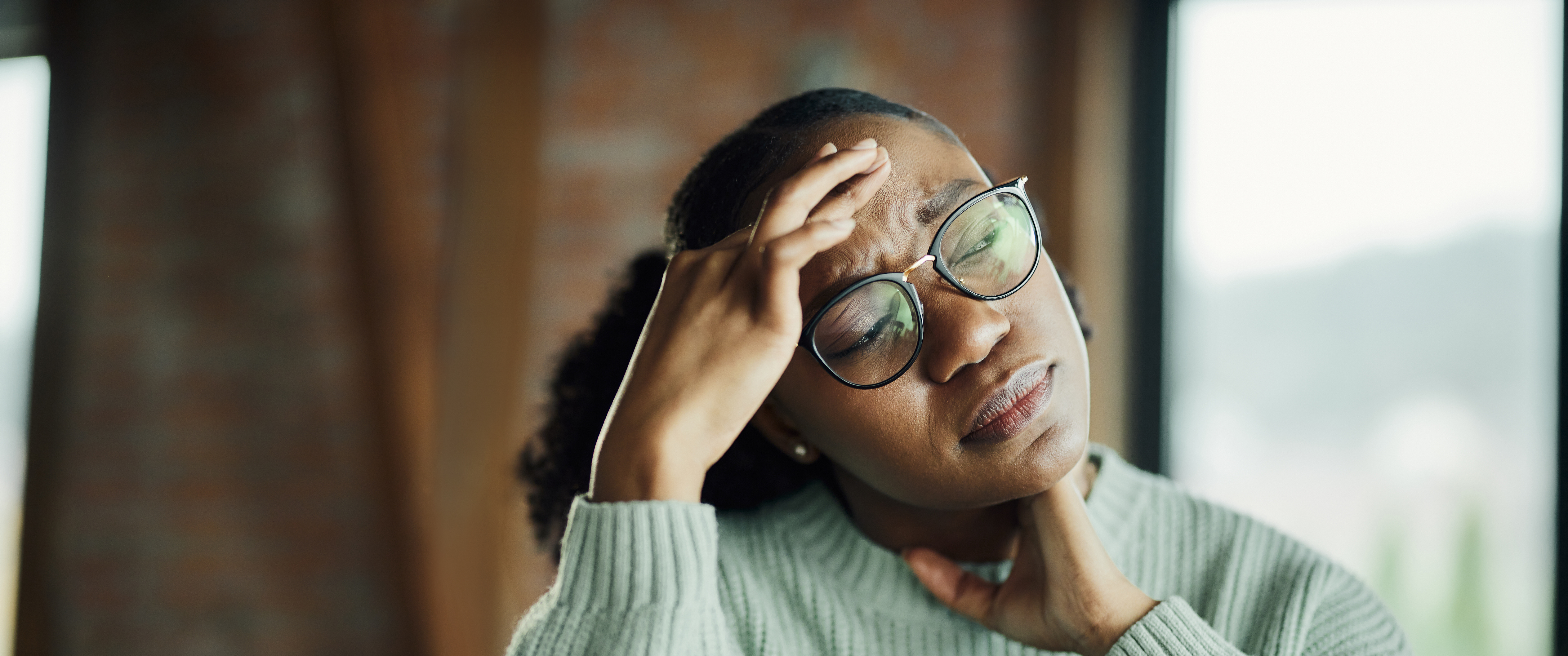 A woman with a headache rubbing her forehead