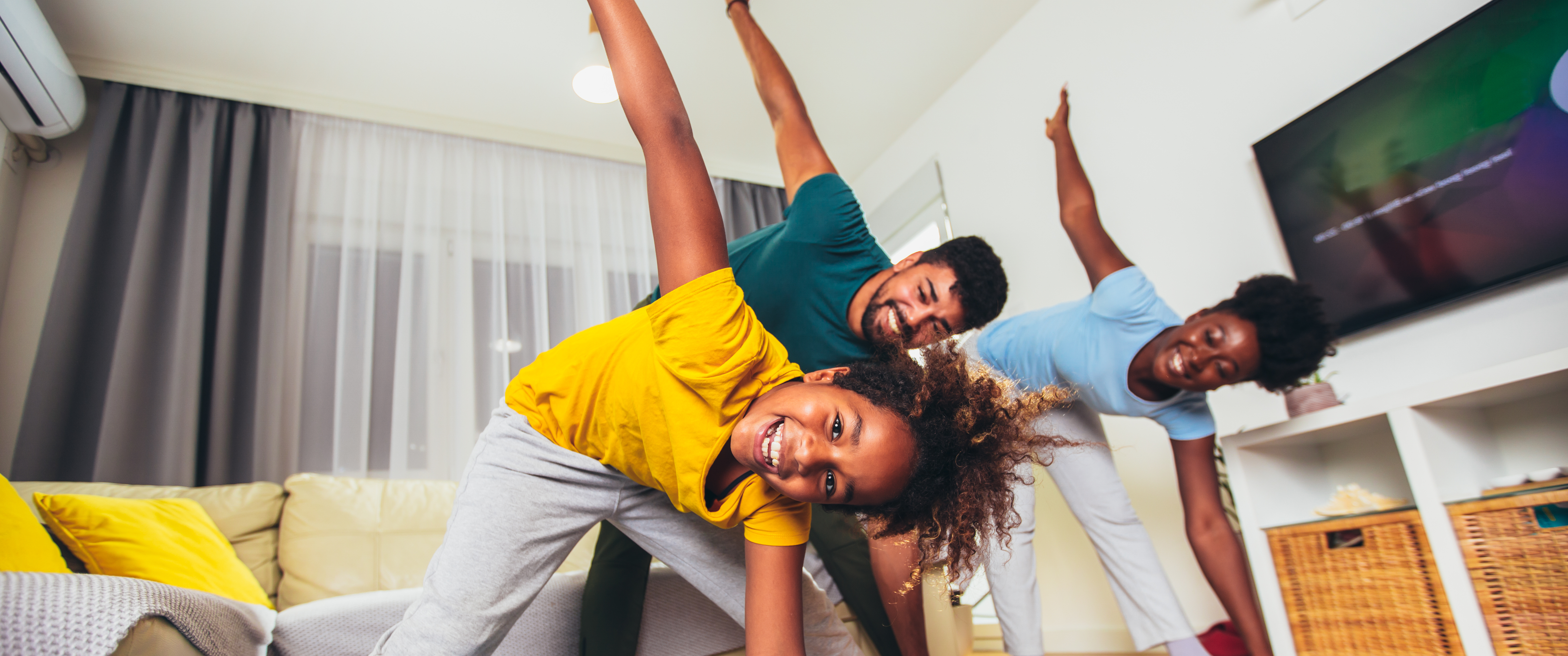 Parents and child smiling while exercising together