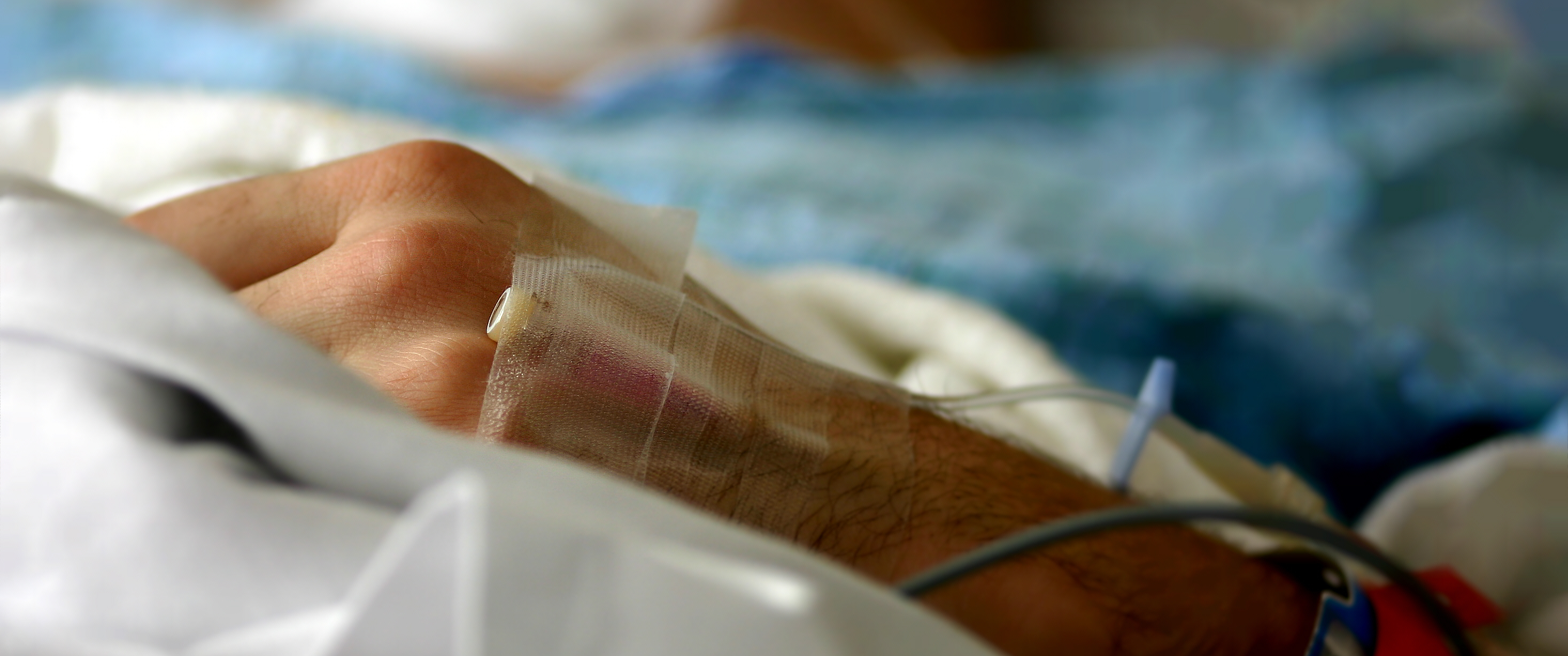 Close-up of hand with IV in a hospital bed