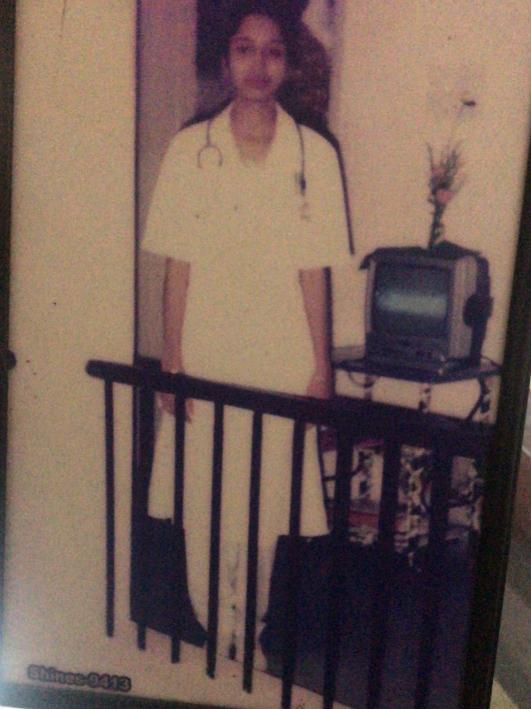 A faded old photo of Abheena Jacob as a young woman wearing a white nursing uniform