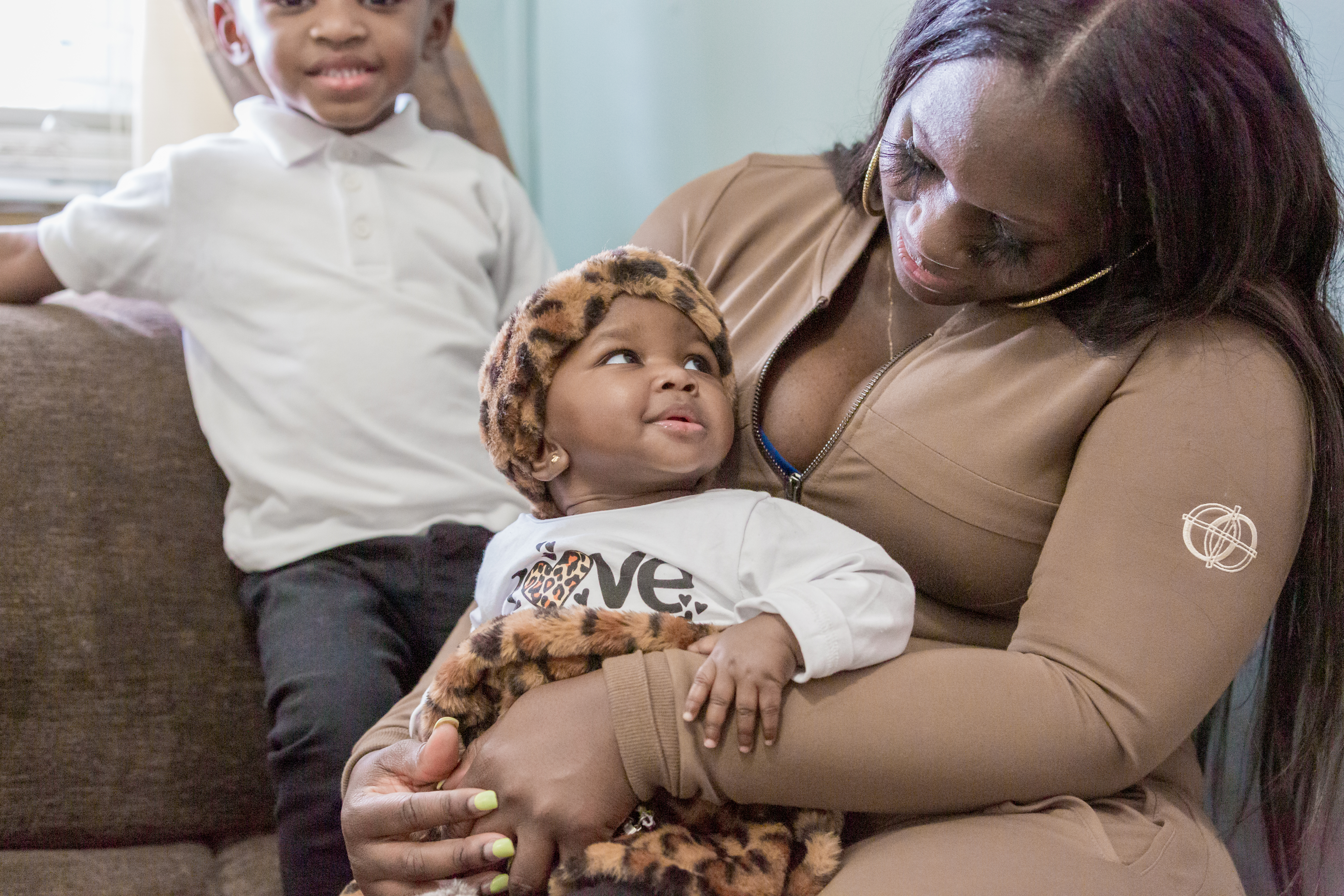 Talicia Williams cuddles her baby girl while her son smiles in the background