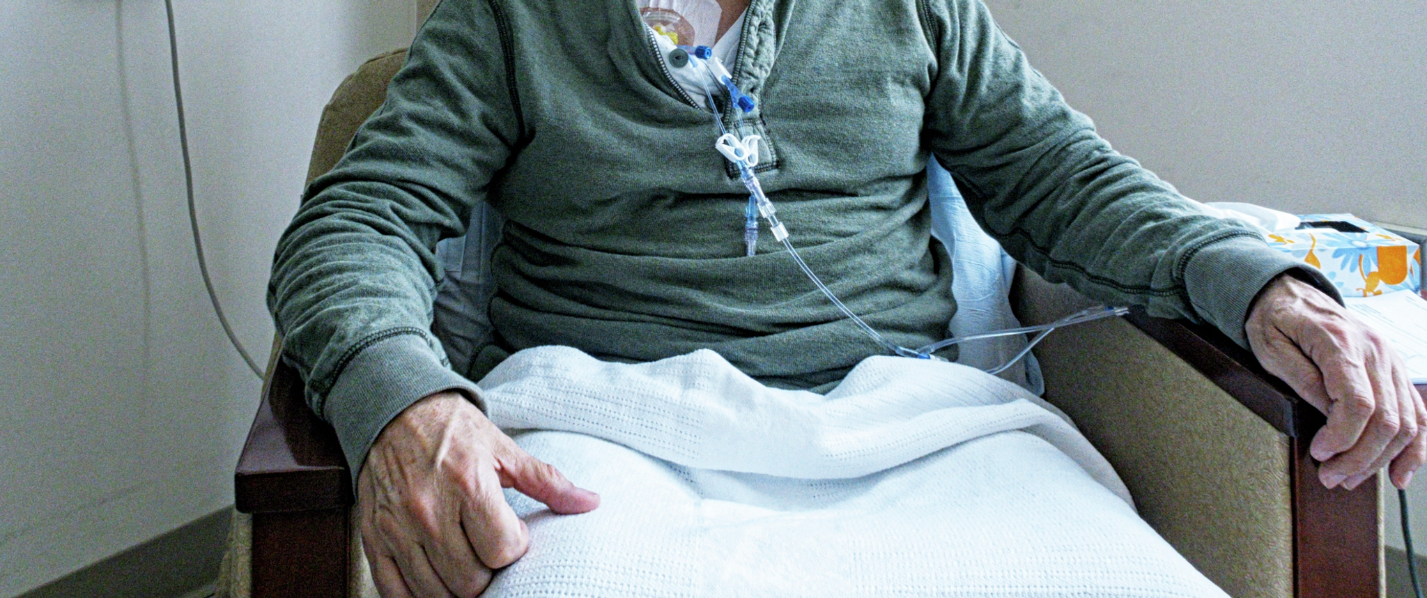 Older adult hands with blood cancer treatment in progress