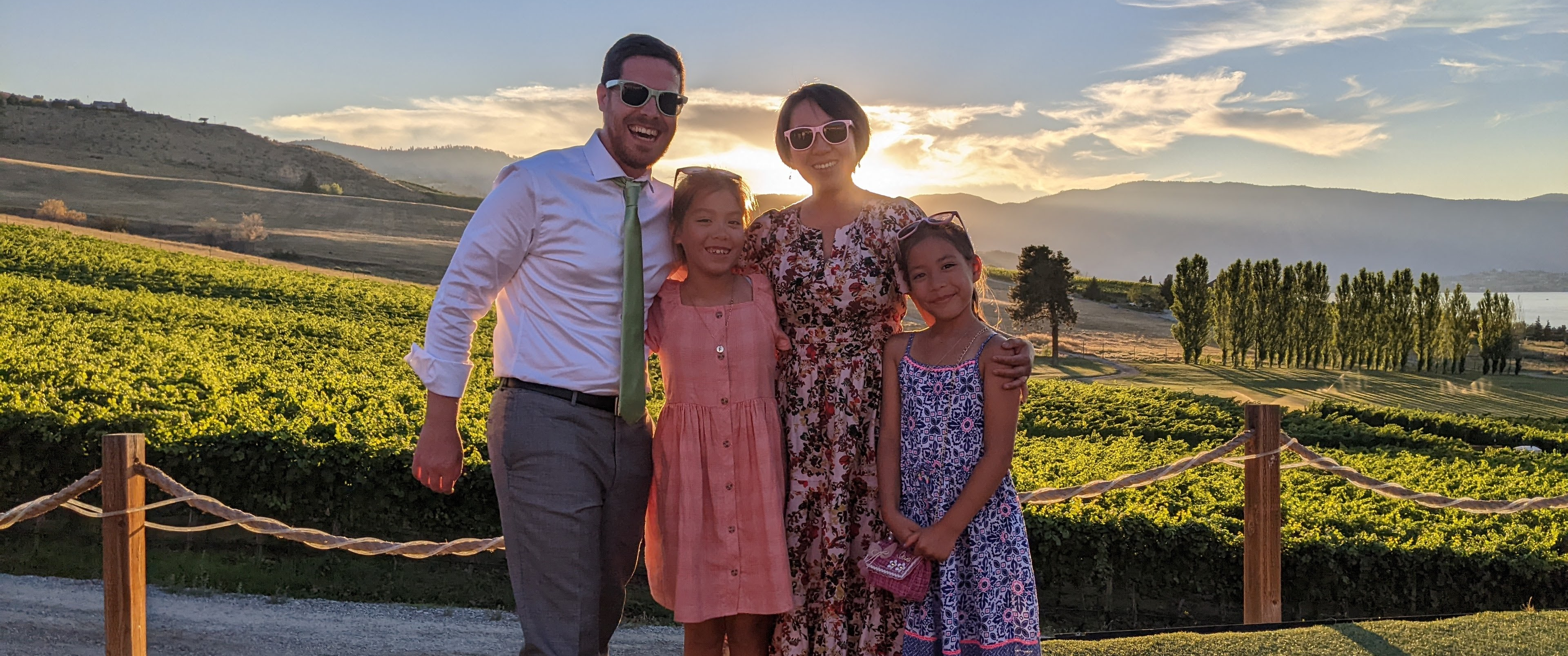Becky Yu with her husband and two school-age daughters standing on a scenic hillside vista