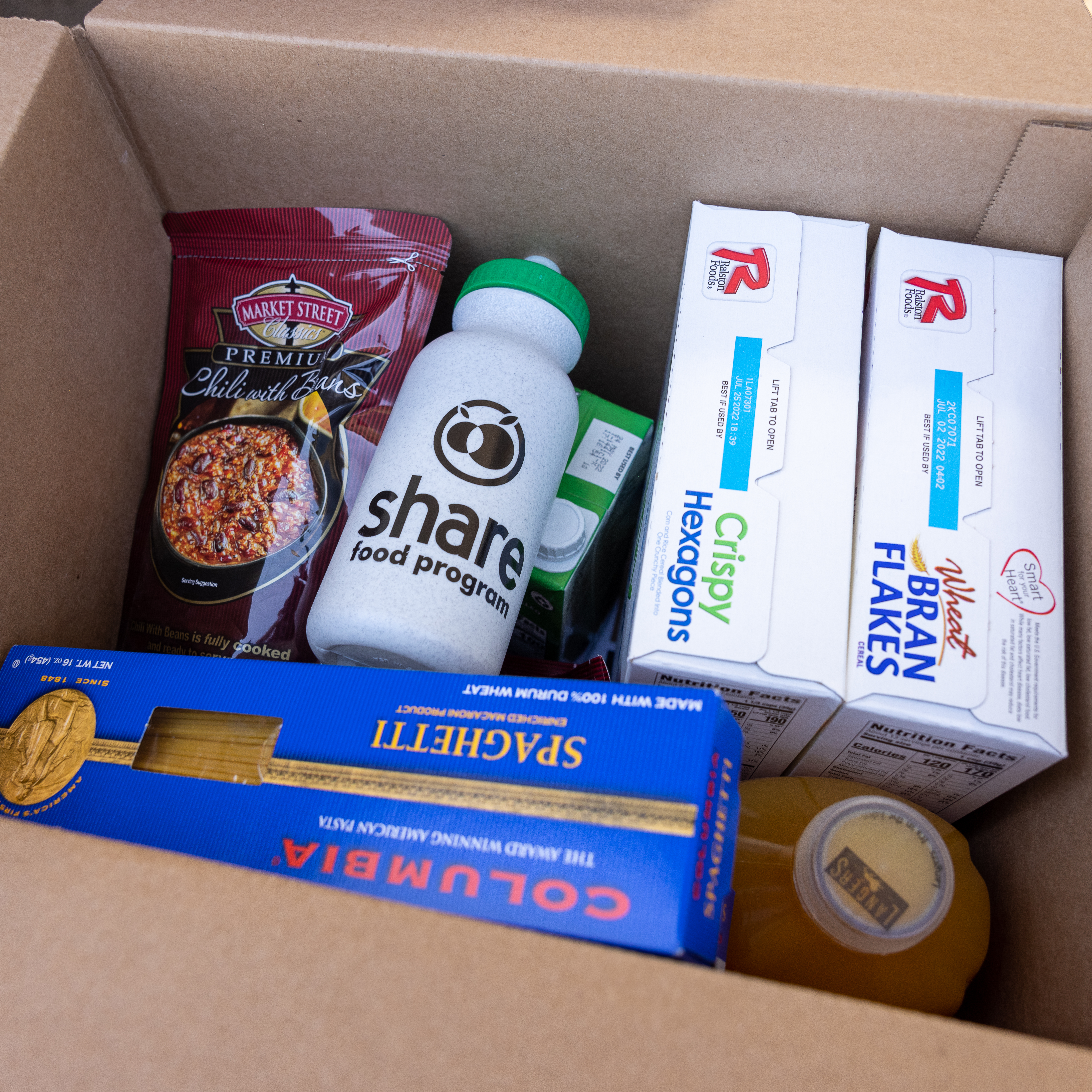 A box filled with packaged foods and a water bottle