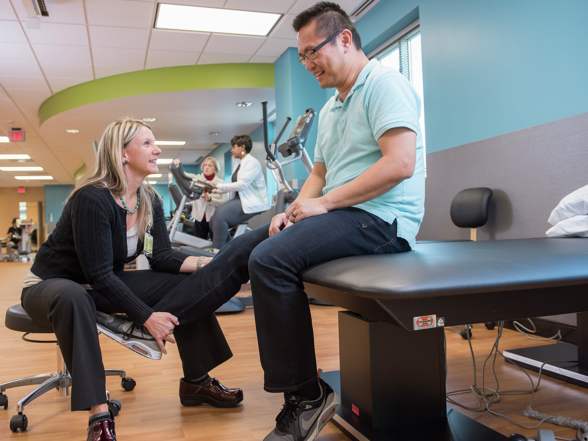 Physical therapist examines patient's knee at Lancaster General Health's Neuroscience Institute Physical Therapy gym.