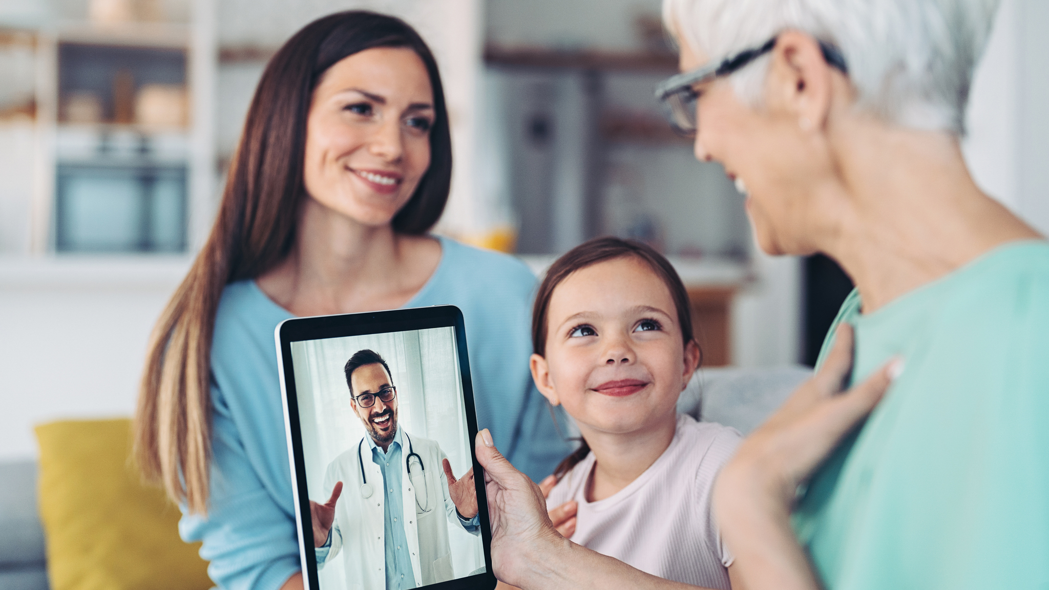 Grandmother, mother and daughter in a telehealth call with a doctor.