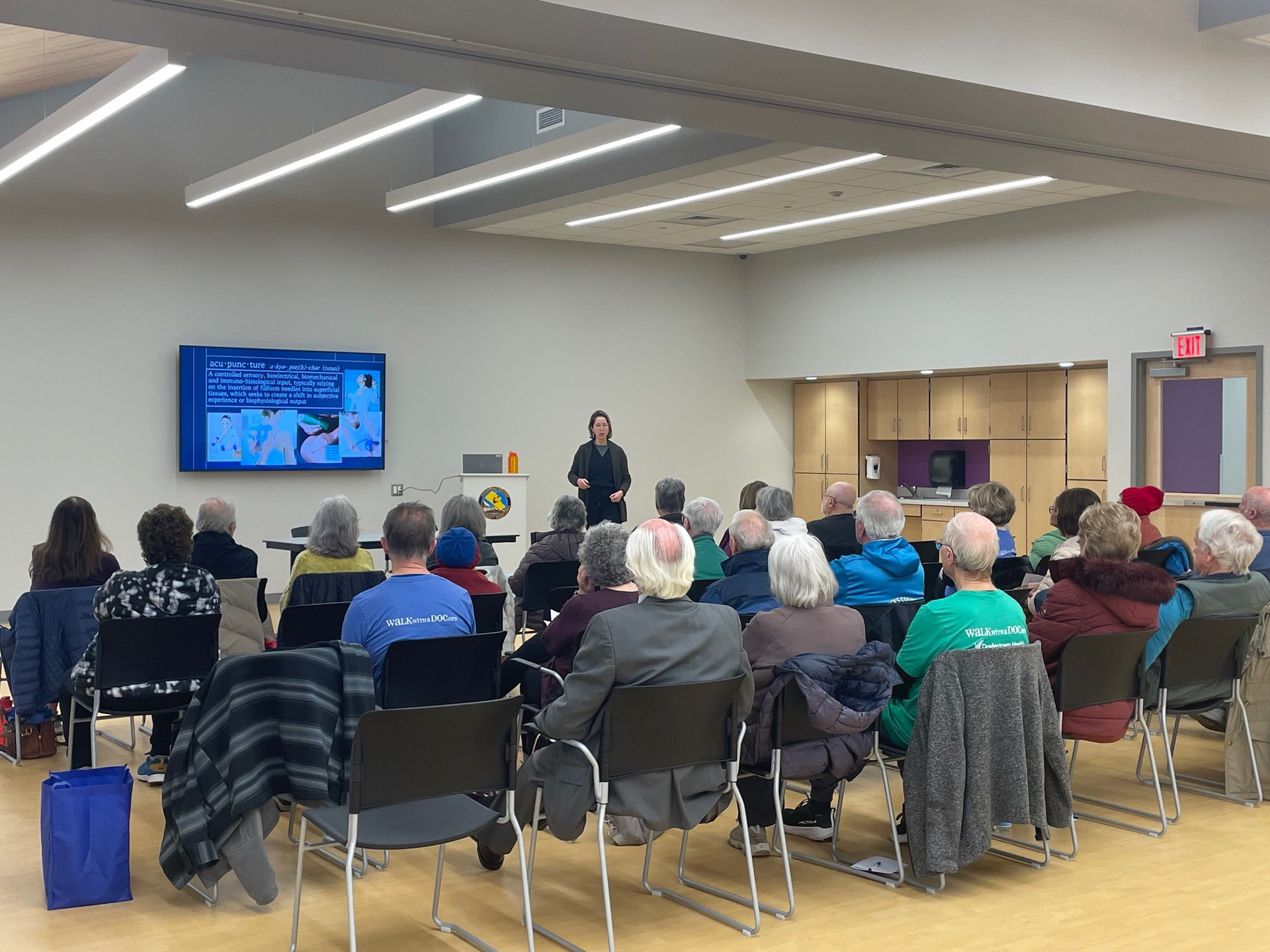 Presenter during a community program session with a large audience