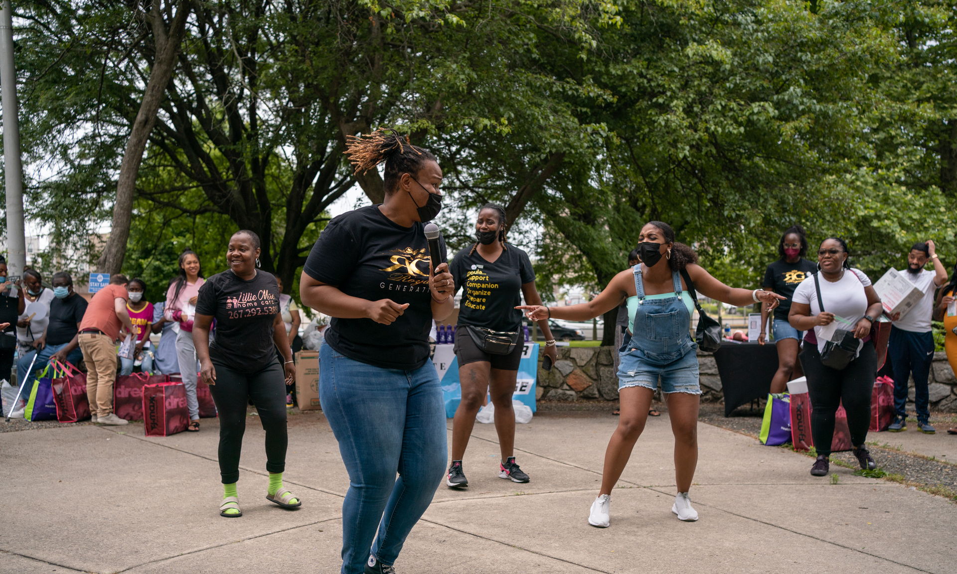 People dance at a community baby shower in a public park