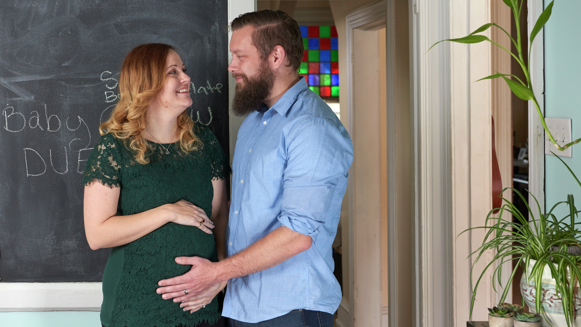 Uterus transplant recipient, Jen Gobrecht, looks lovingly at husband, Drew, as he touches her pregnant belly