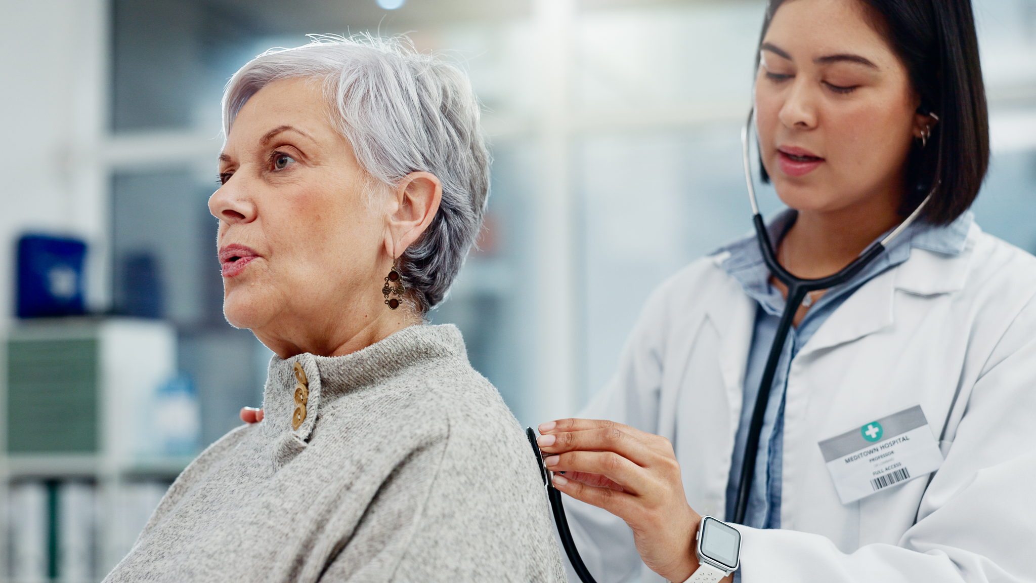 Senior woman, doctor and stethoscope for breathing on back to listen for lung problem