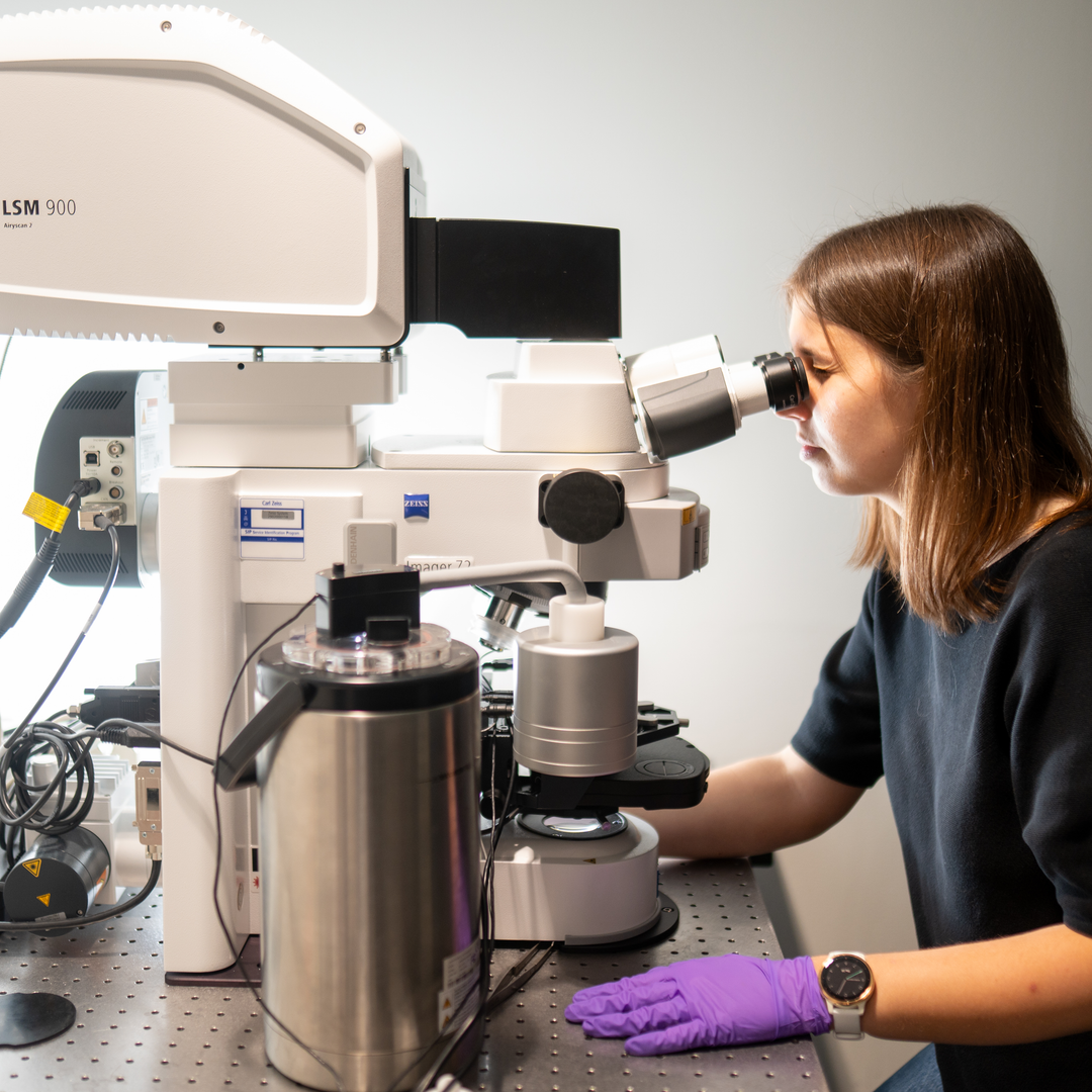 Kathryn Kixmoeller looks into a microscope