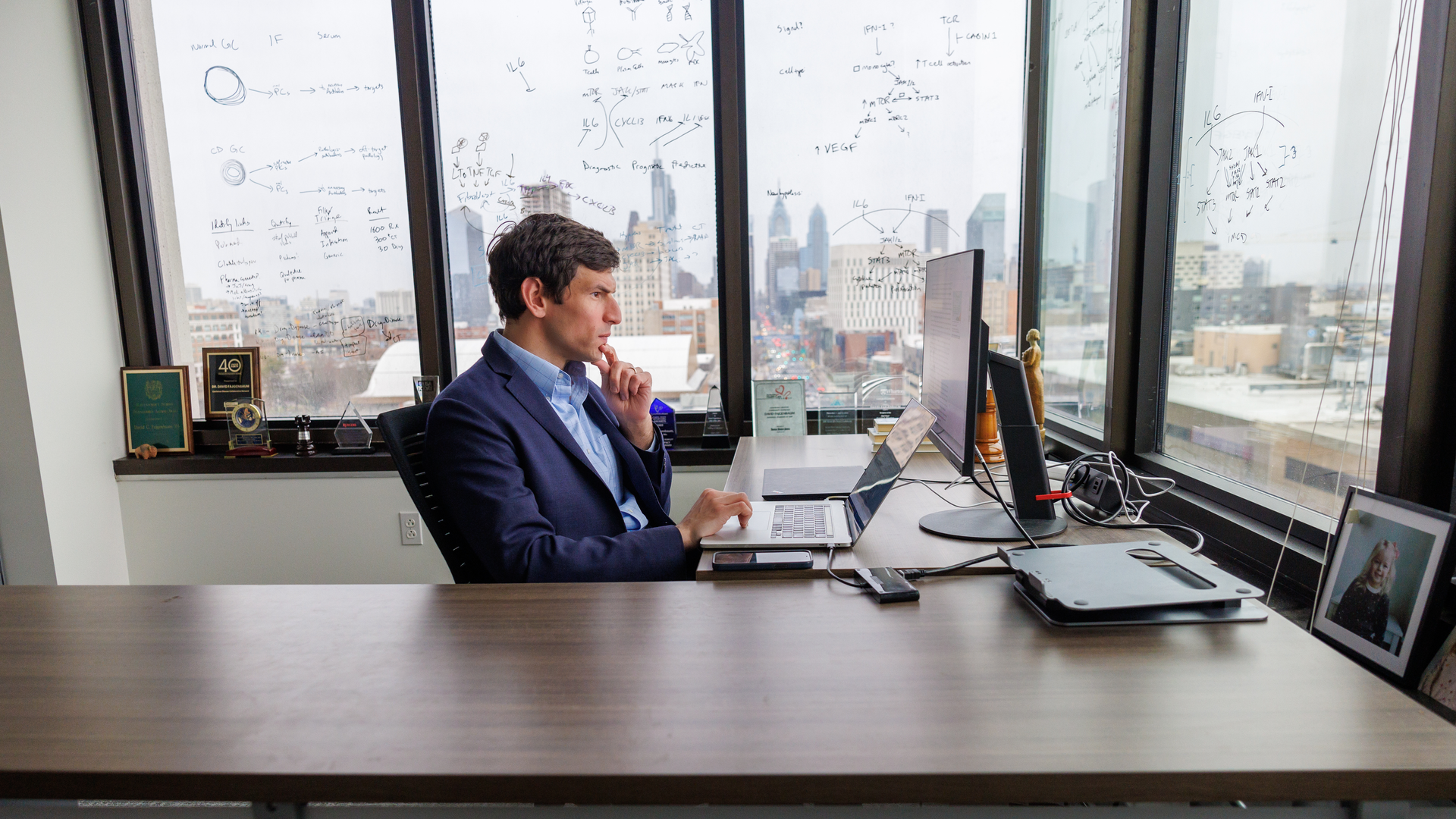 David Fajgenbaum, seen in profile seated at a desk with his hand thoughtfully on his chin