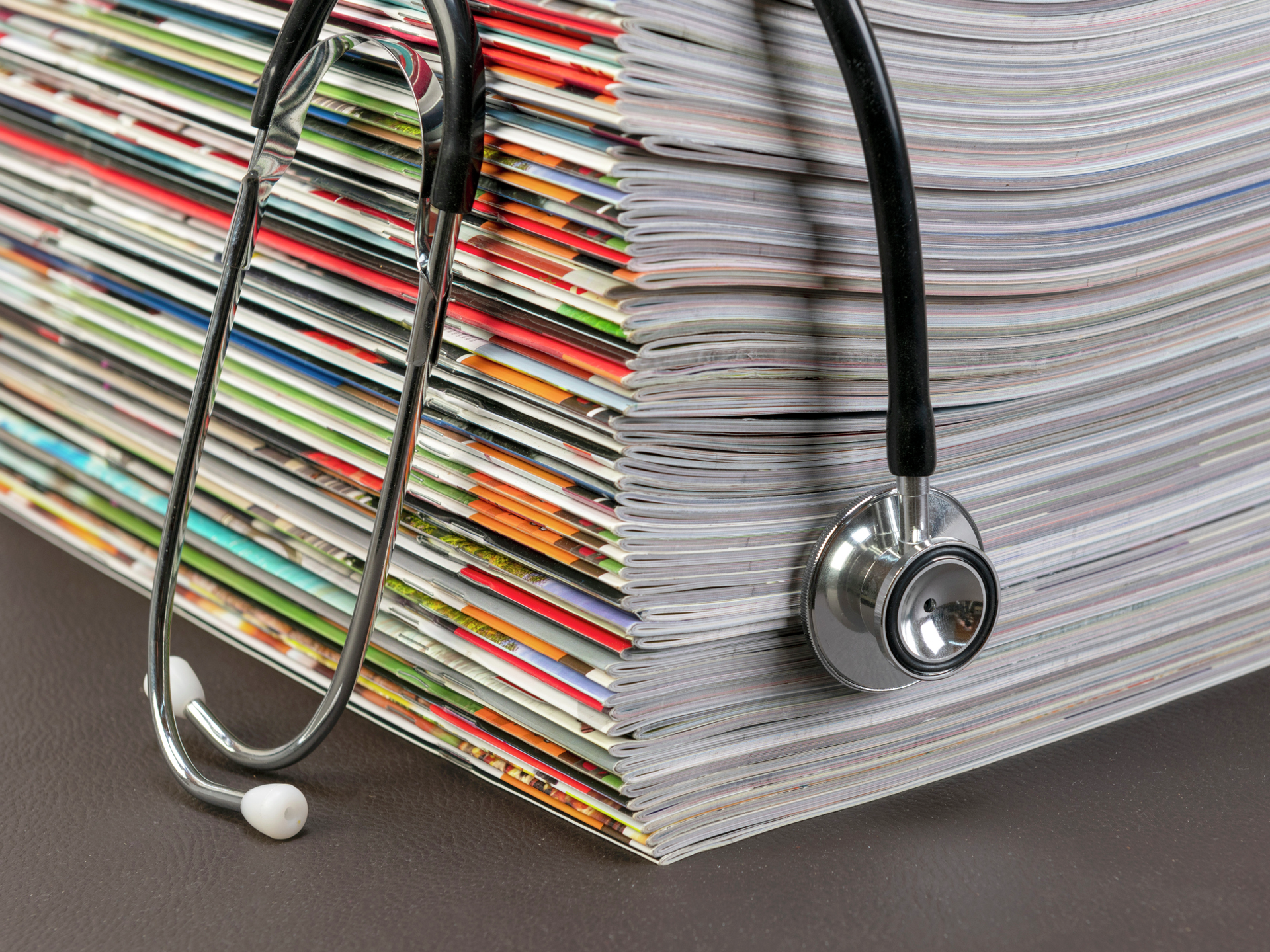 A stethoscope on a stack of medical journals