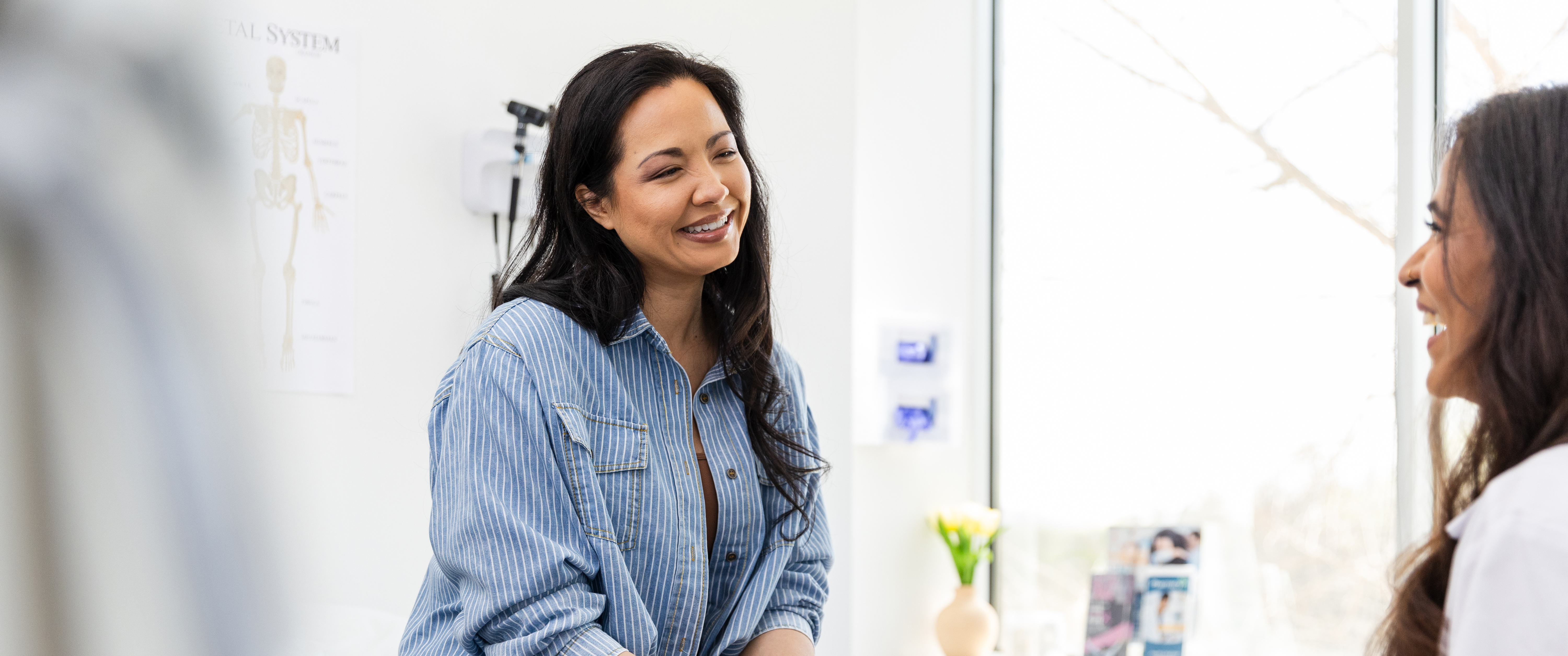 Patient and doctor laughing in exam room during appointment