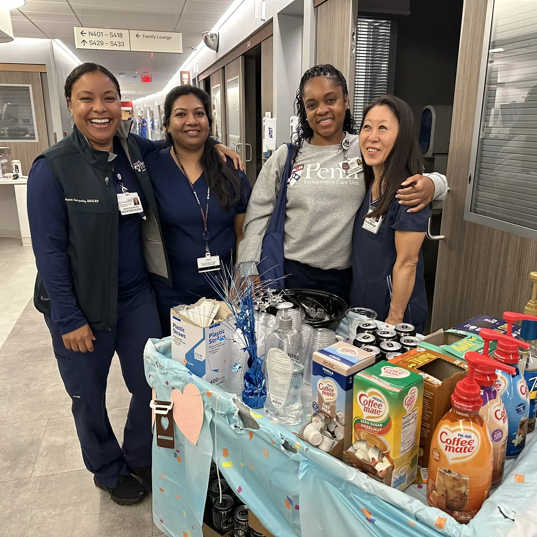Four HUP employees standing next to a coffee cart