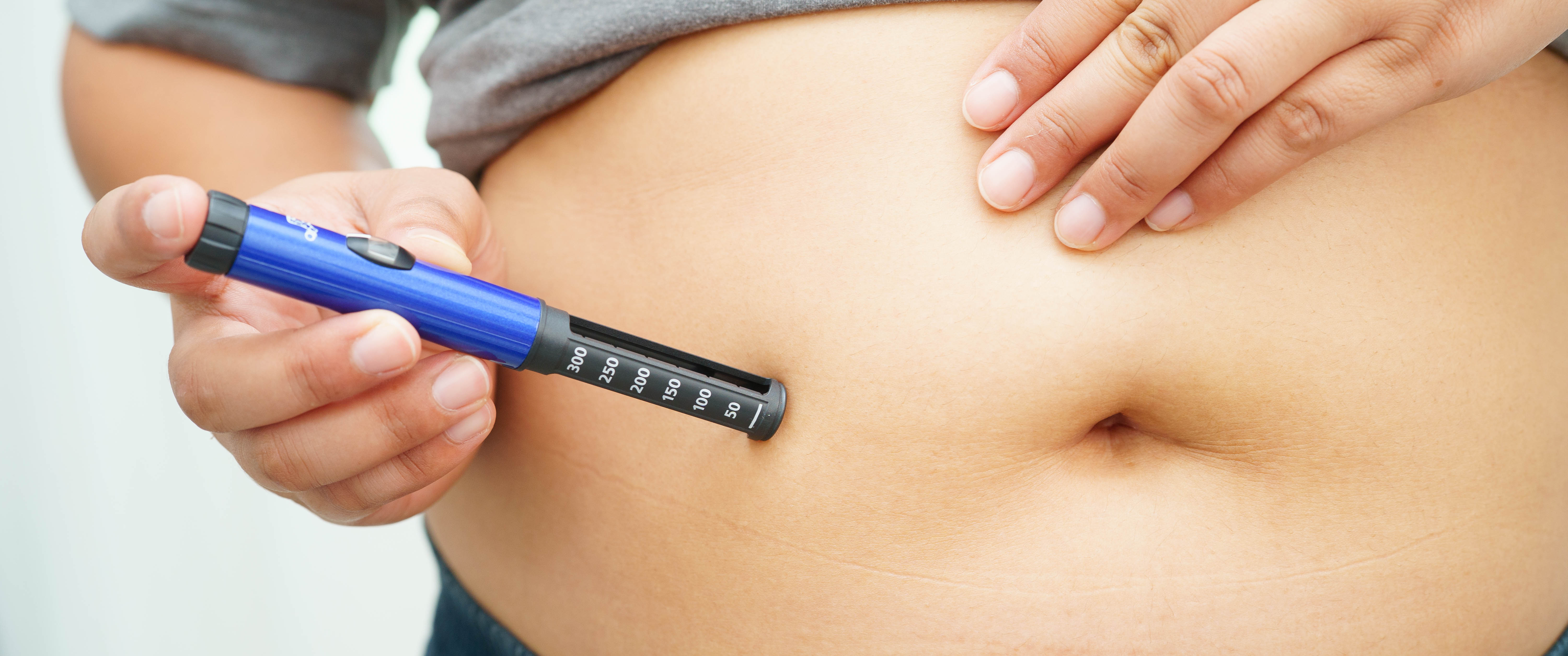 Woman applying obesity treatment on her belly.