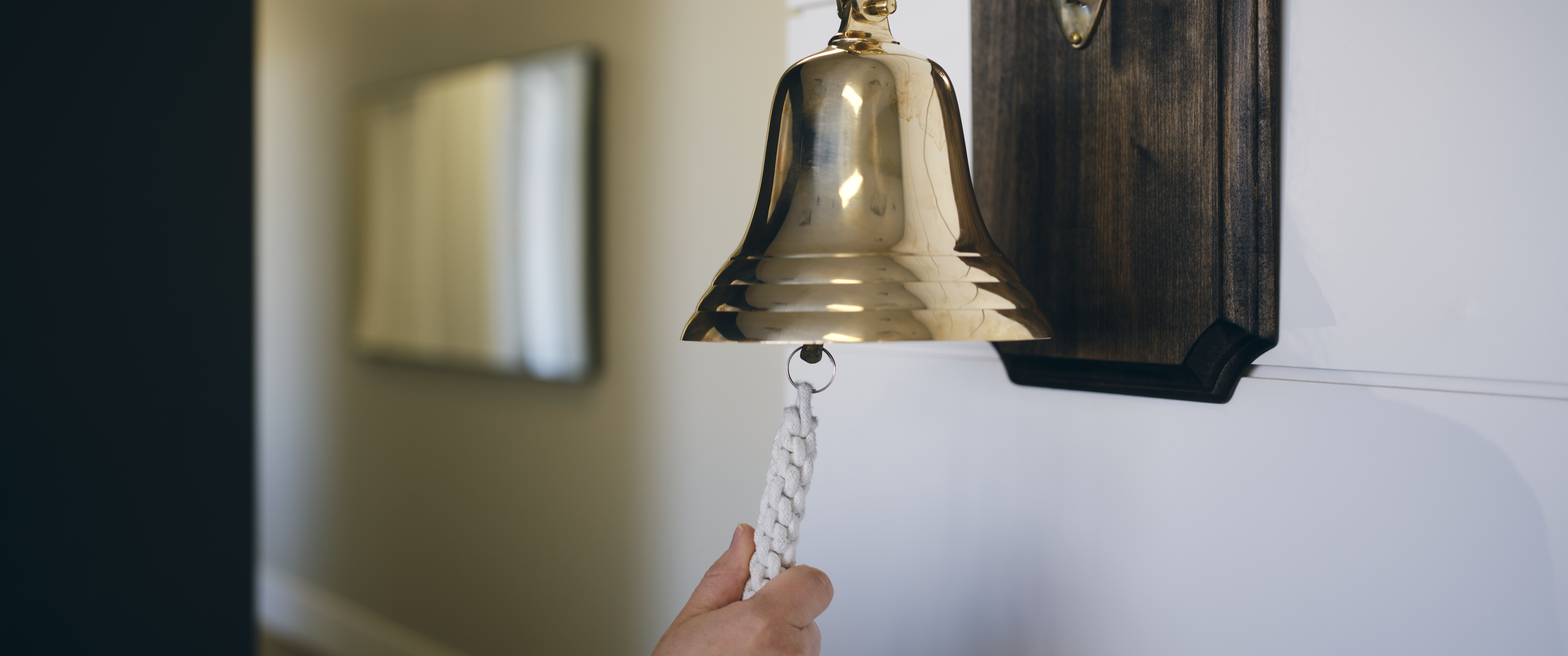 A hand ringing the cancer bell at a hospital. 