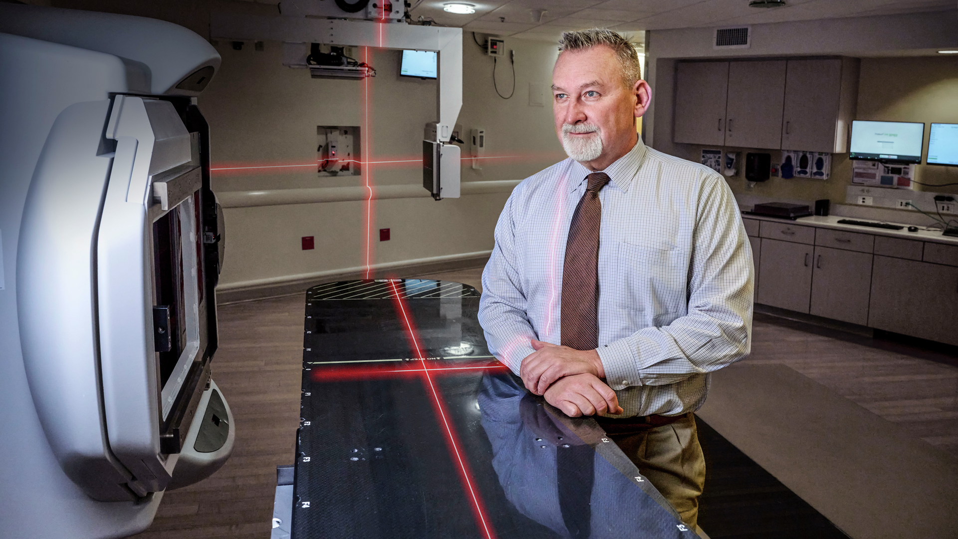 James Metz MD standing next to proton therapy device