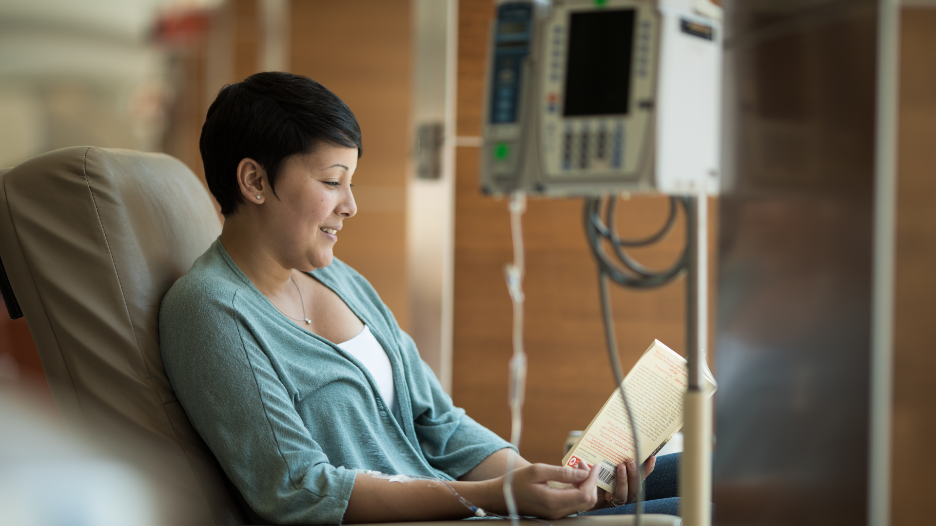 Cancer patient reading a book while receiving infusion therapy
