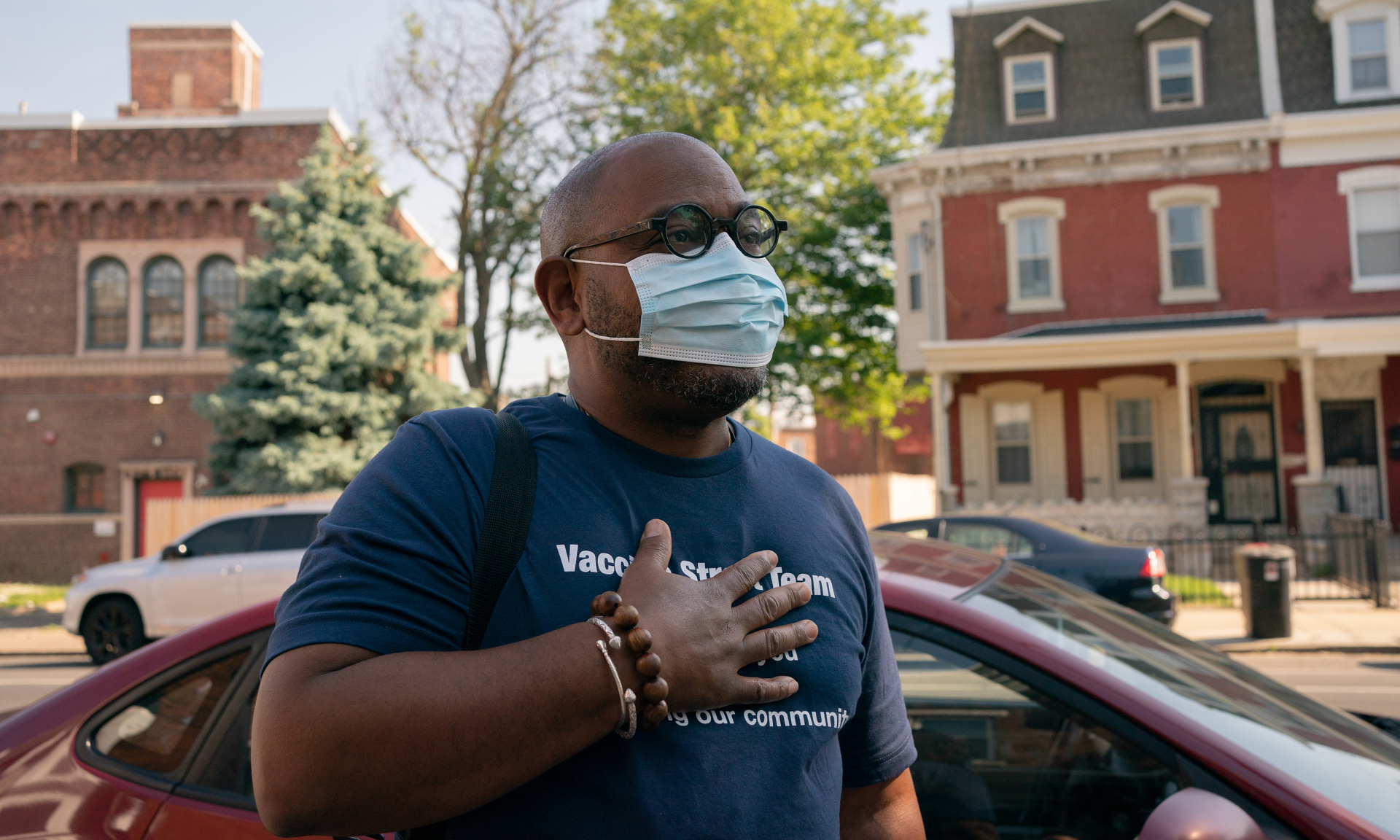 Yuhnis Syndor, masked, holds his hand at his heart