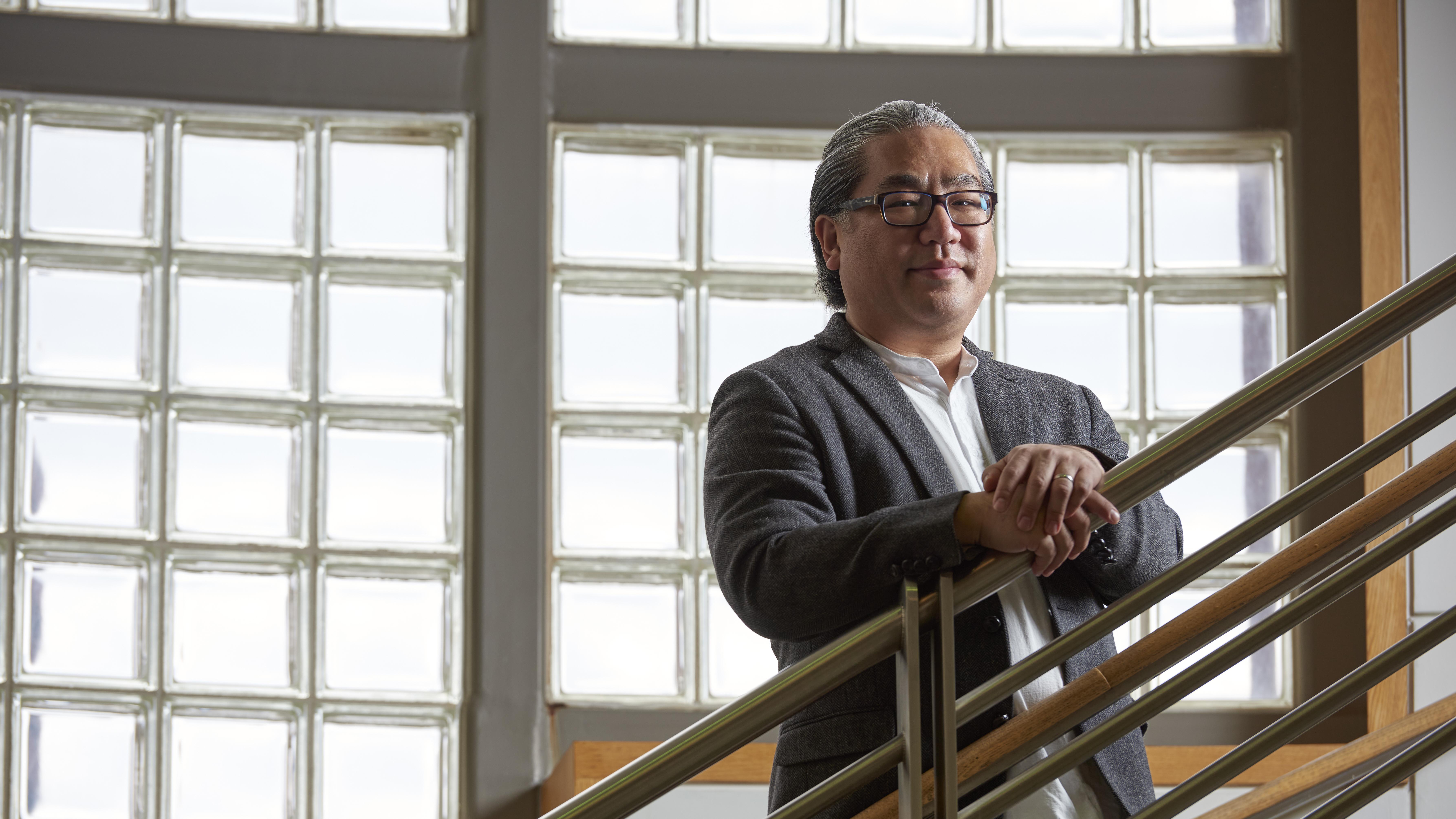 Portrait of Edward Lee, MD, PhD, looking over a staircase railing