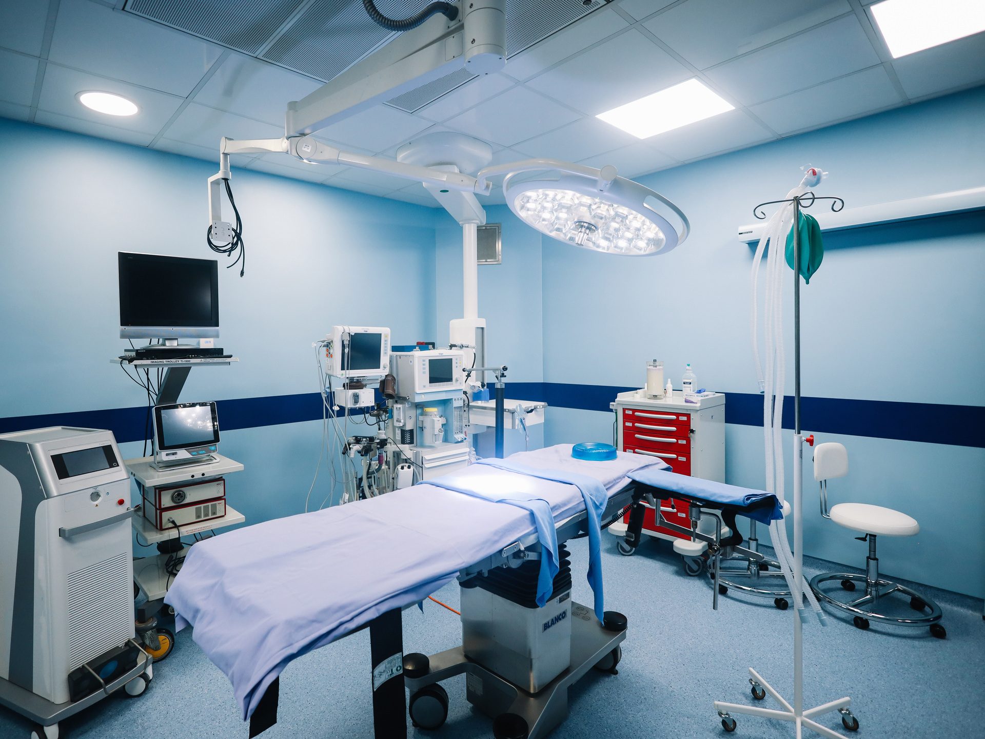 An operating room with an empty bed at the center.