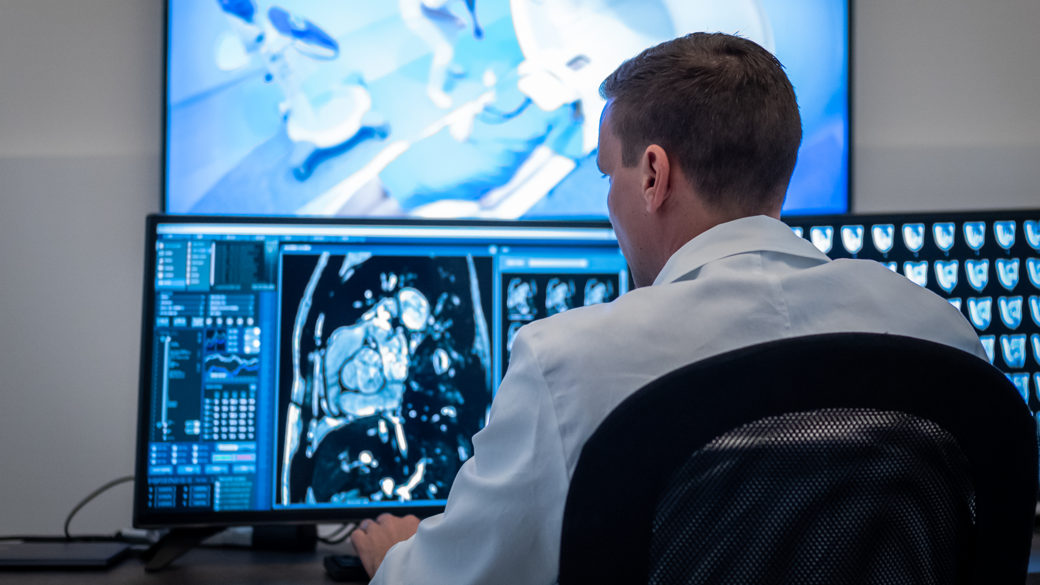 Back view of male radiologist during magnetic resonance imaging scanning. Examination at specialized medical clinic, diagnosis and healthcare concept.
